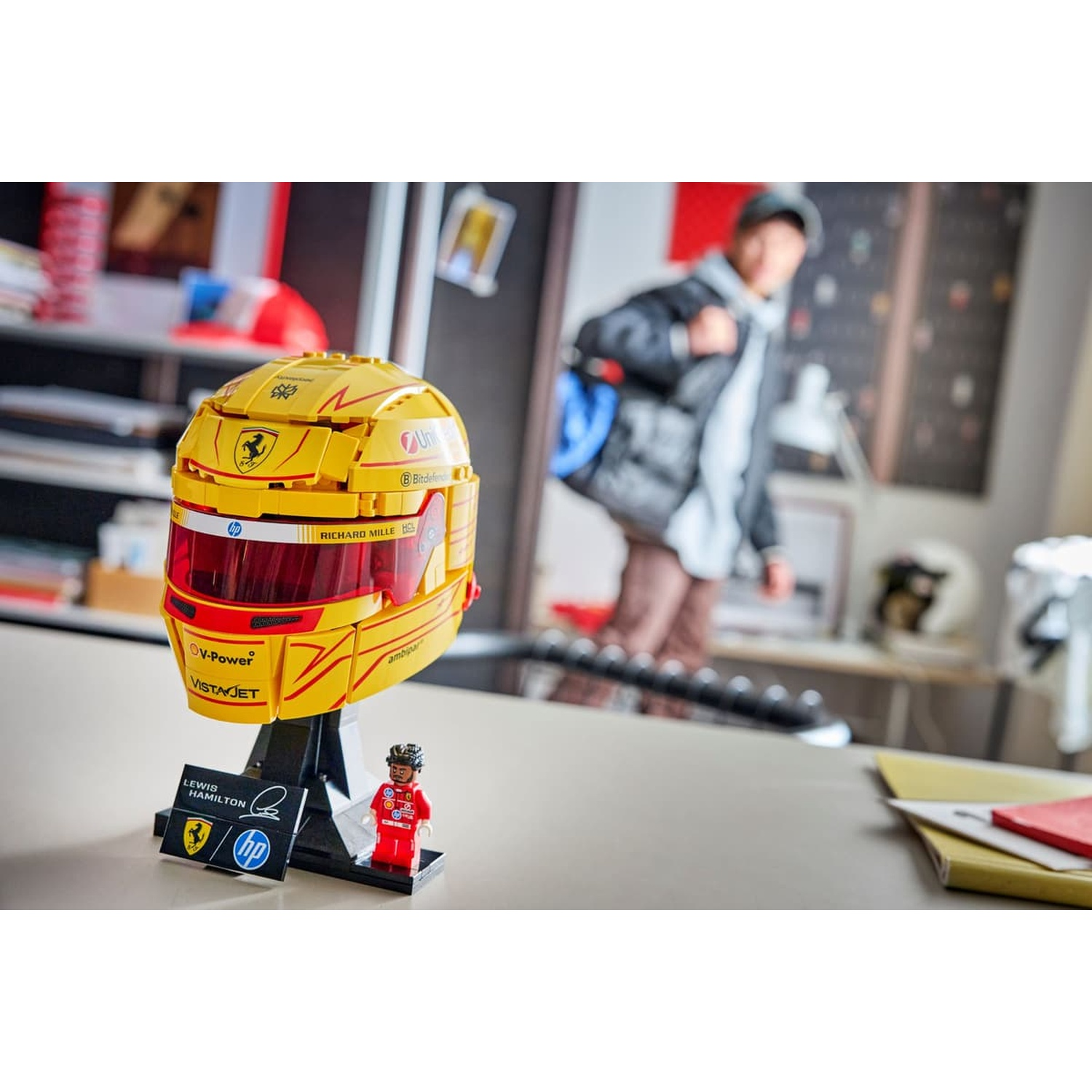 Casco Lego giallo con decalcomanie Ferrari e minifigure di Lewis Hamilton.