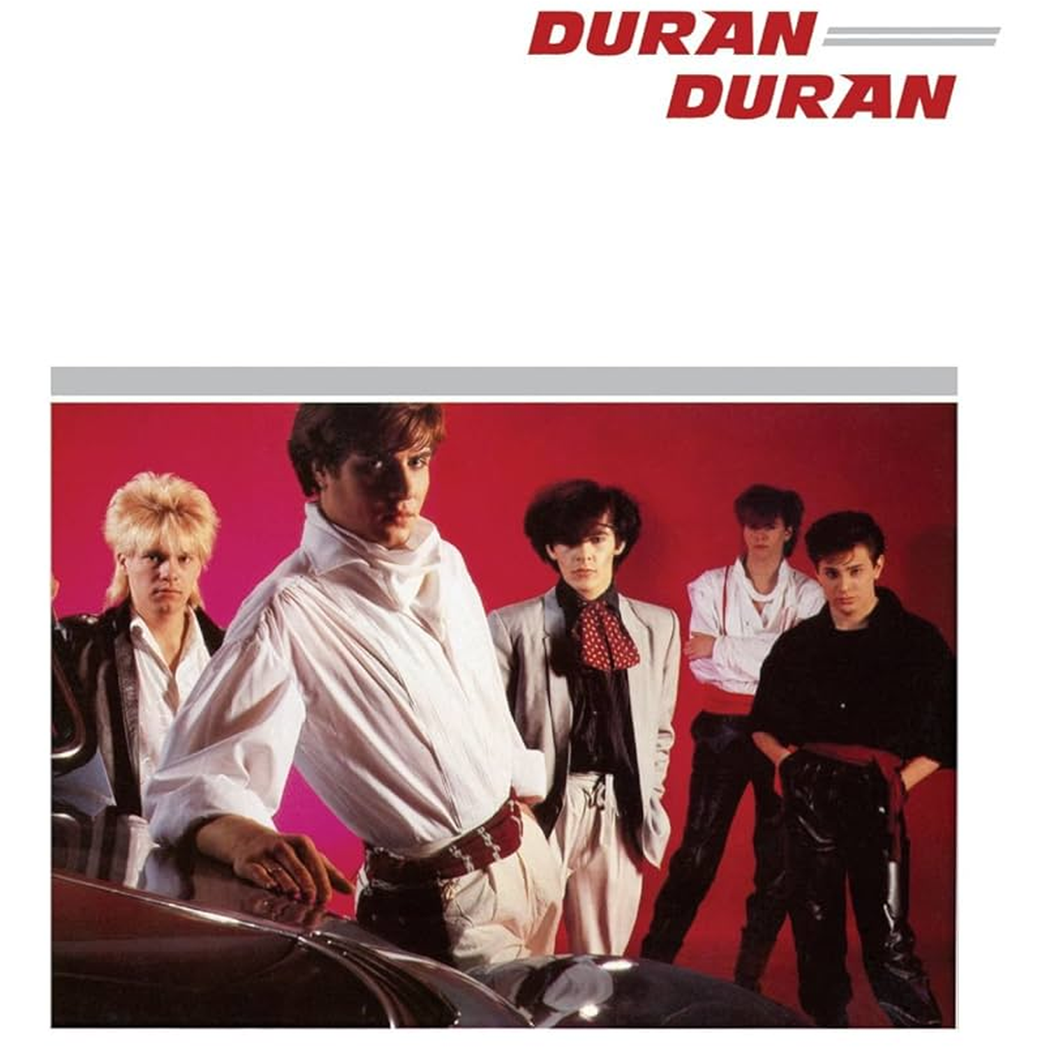 Vijf mannen in modieuze kleding tegen een rode achtergrond met Duran Duran logo.