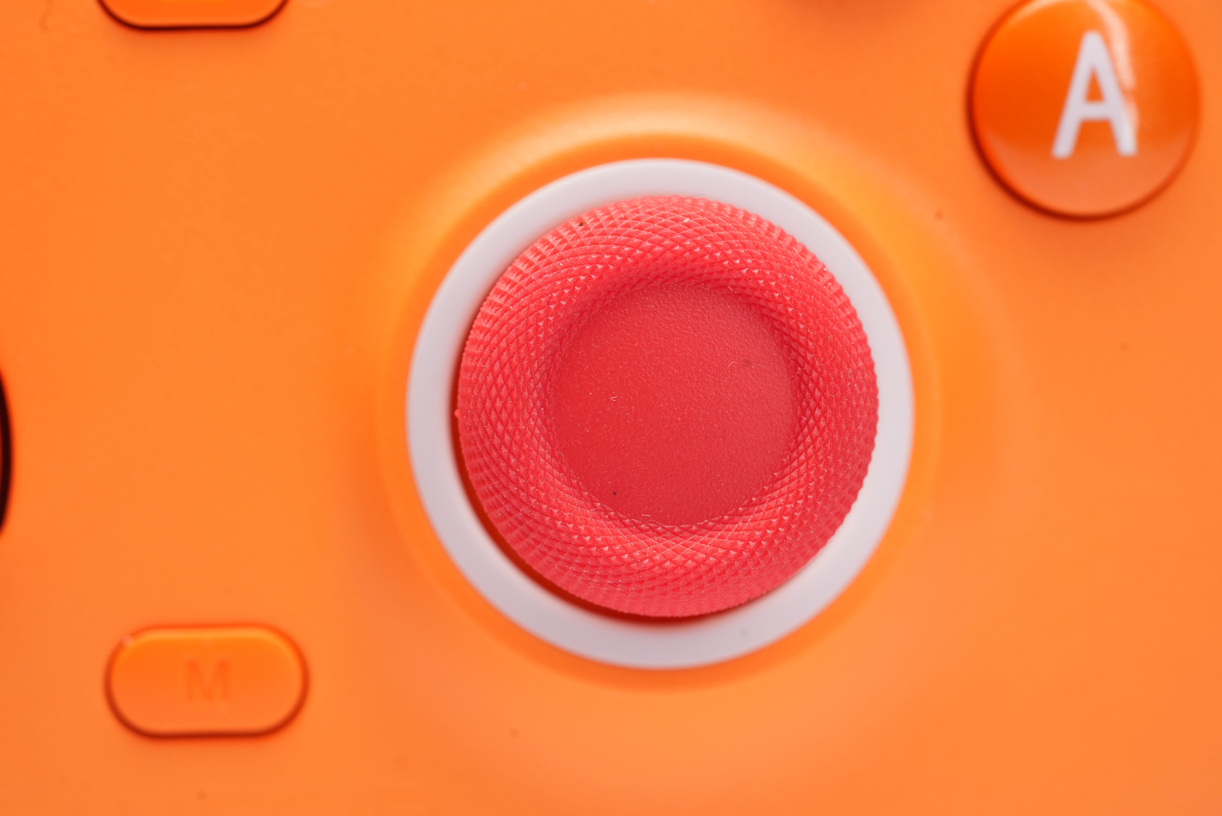 Orange Gamecontroller mit roten und weißen Tasten.