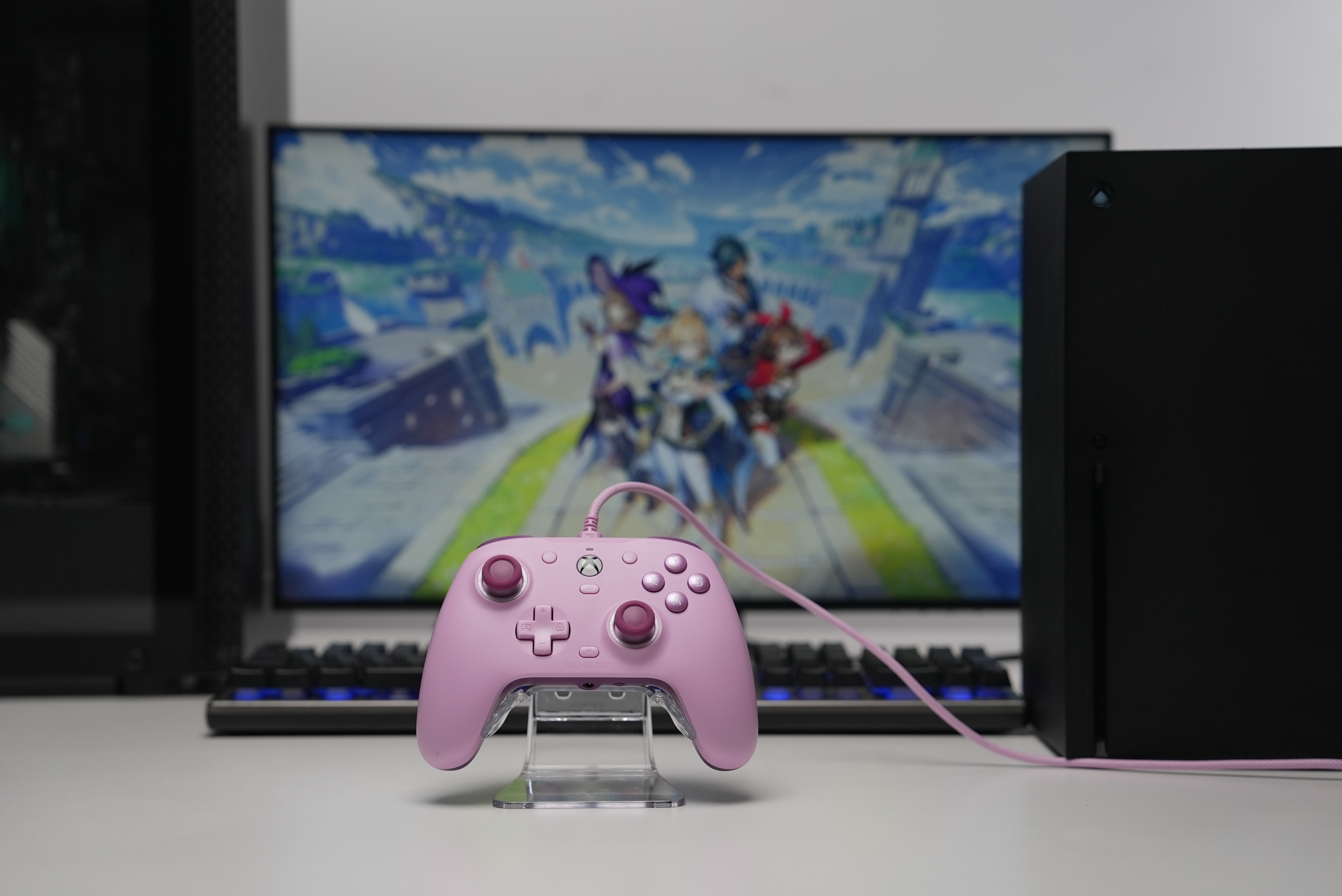 Ein rosafarbener Controller steht vor einem Monitor mit Anime-Figuren.