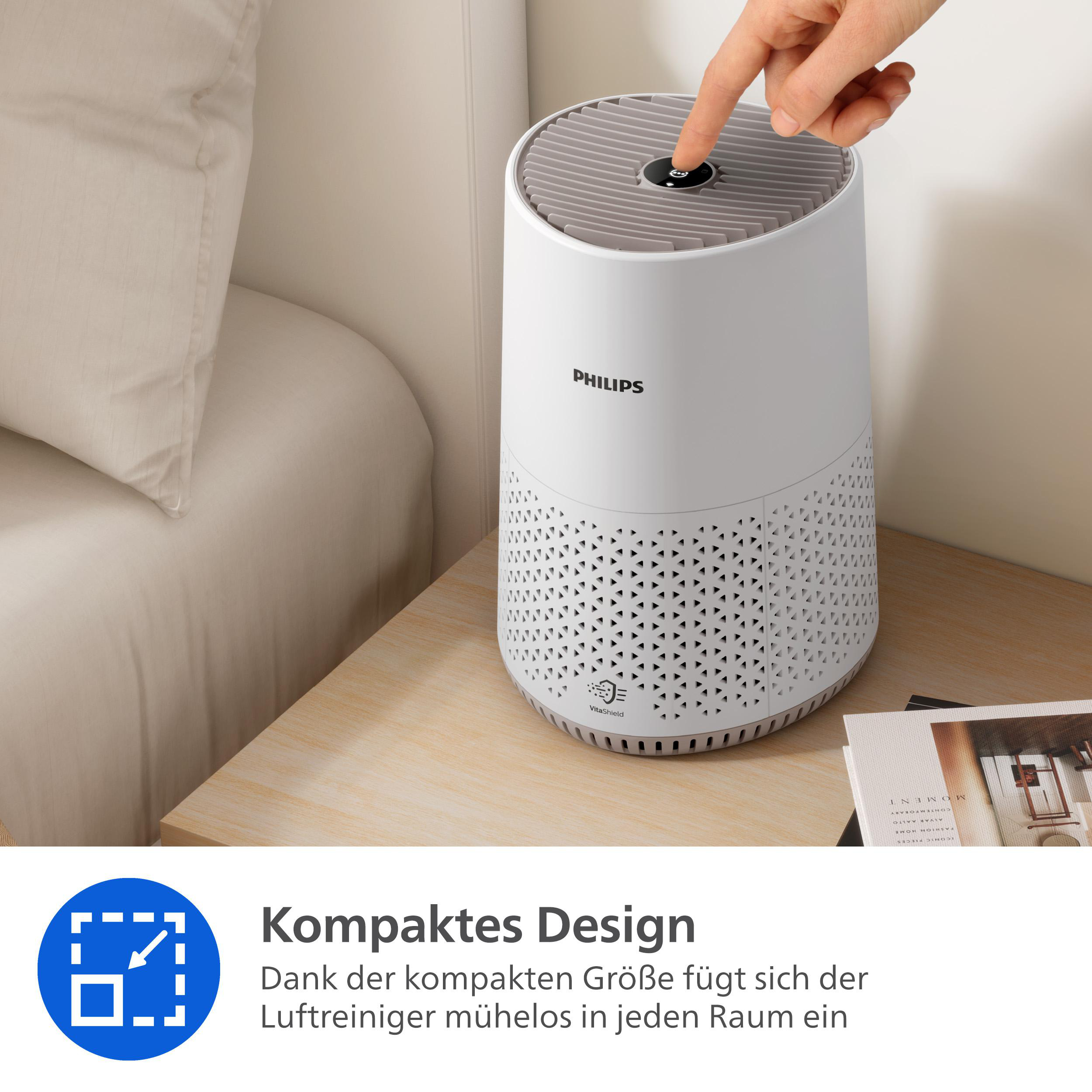 Ein weißer Philips Luftreiniger steht auf einem Nachttisch neben einem Bett.