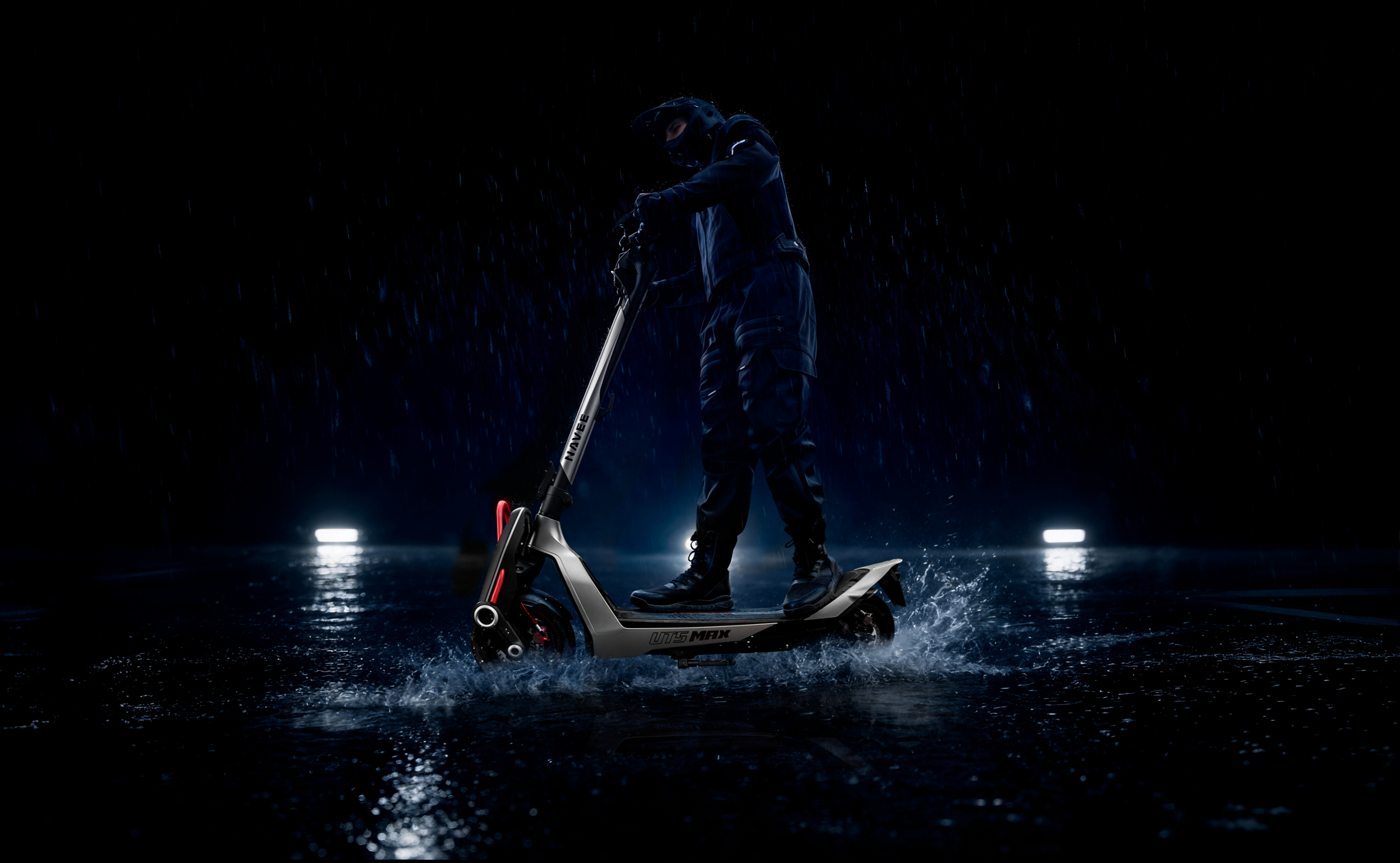 Person fährt E-Scooter im Regen auf nassem Asphalt, Lichter im Hintergrund.