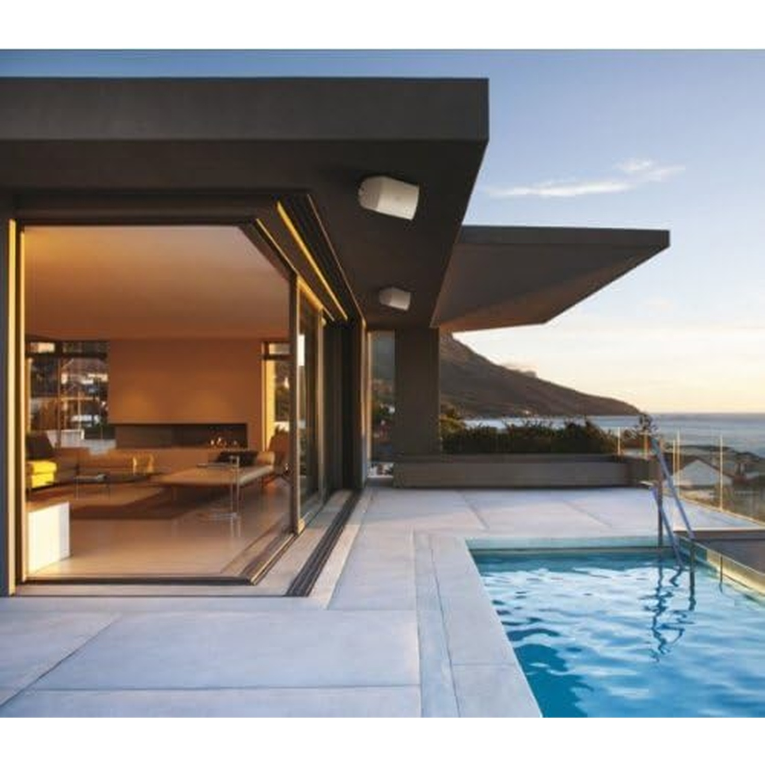 Casa moderna con piscina e vista mare al tramonto.