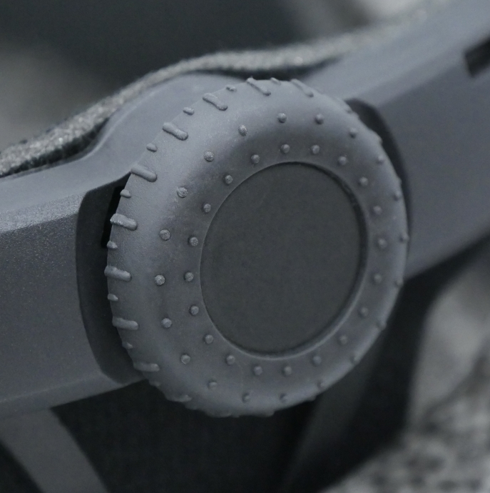 Szary pokrętło regulacyjne z wypustkami i rowkami, część urządzenia.