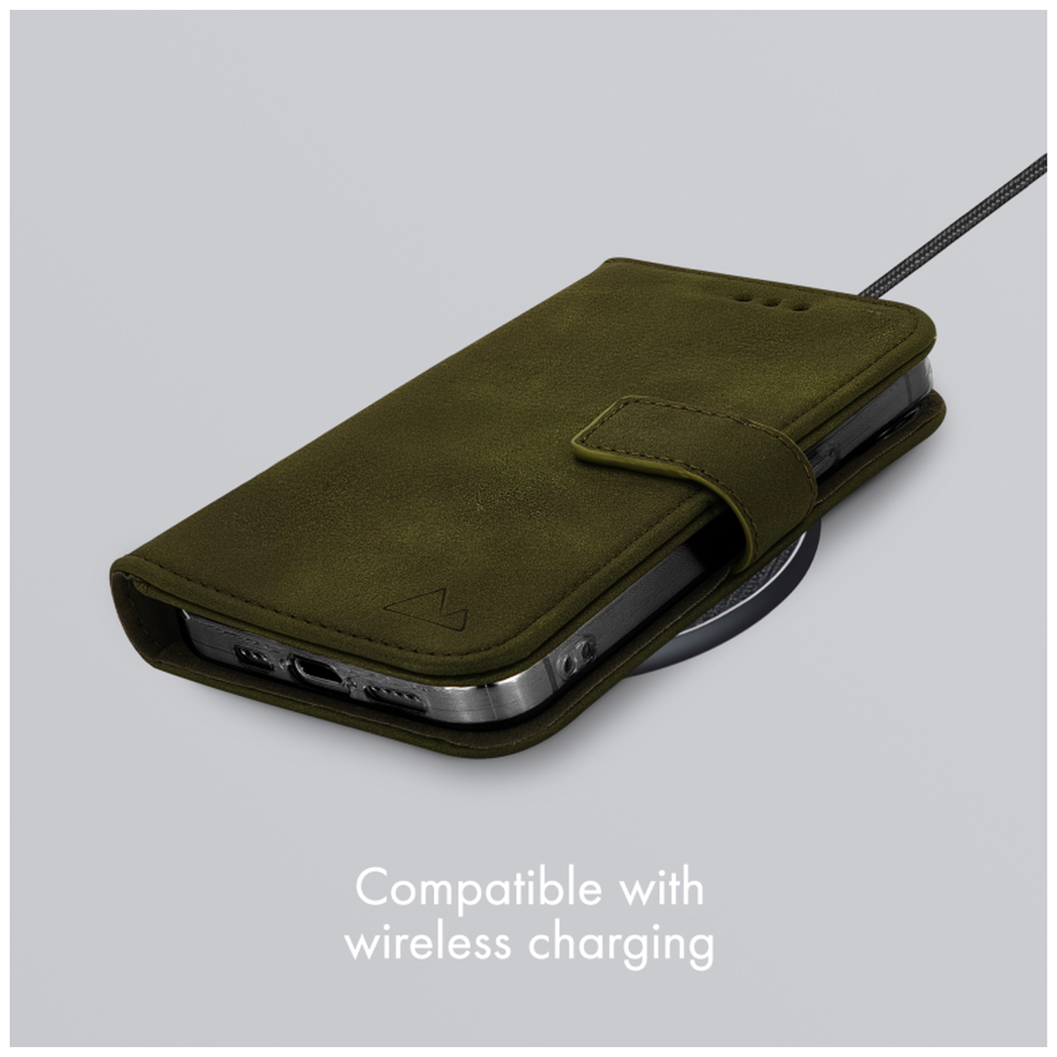 Un étui de téléphone vert repose sur un chargeur sans fil.