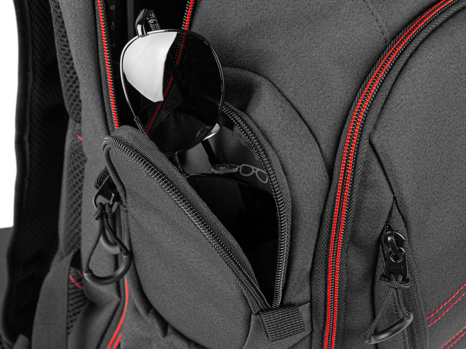 Okulary przeciwsłoneczne w zapinanej na zamek kieszeni plecaka z czerwonymi akcentami.