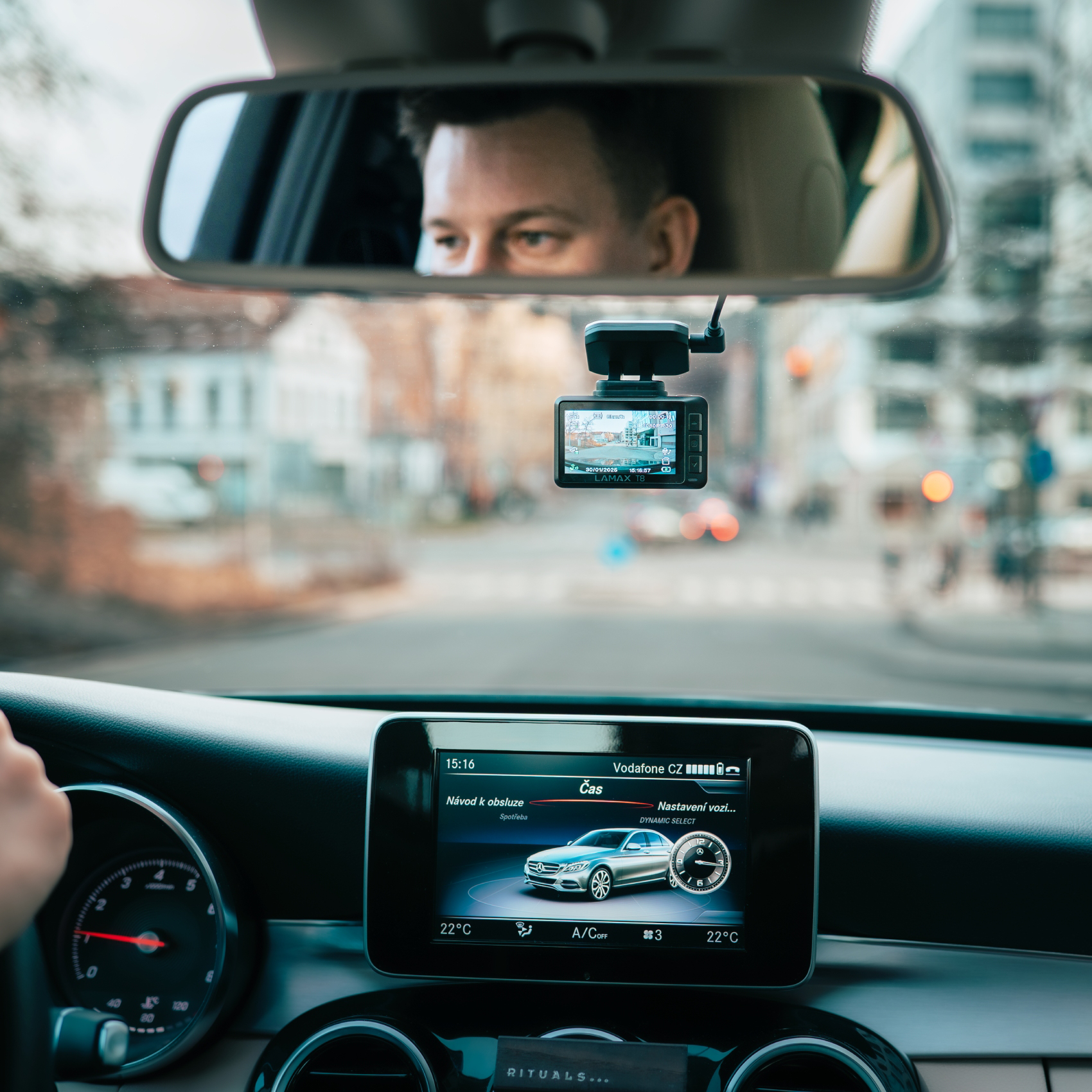 Egy férfi a visszapillantó tükörbe néz vezetés közben. Dashcam van rögzítve.