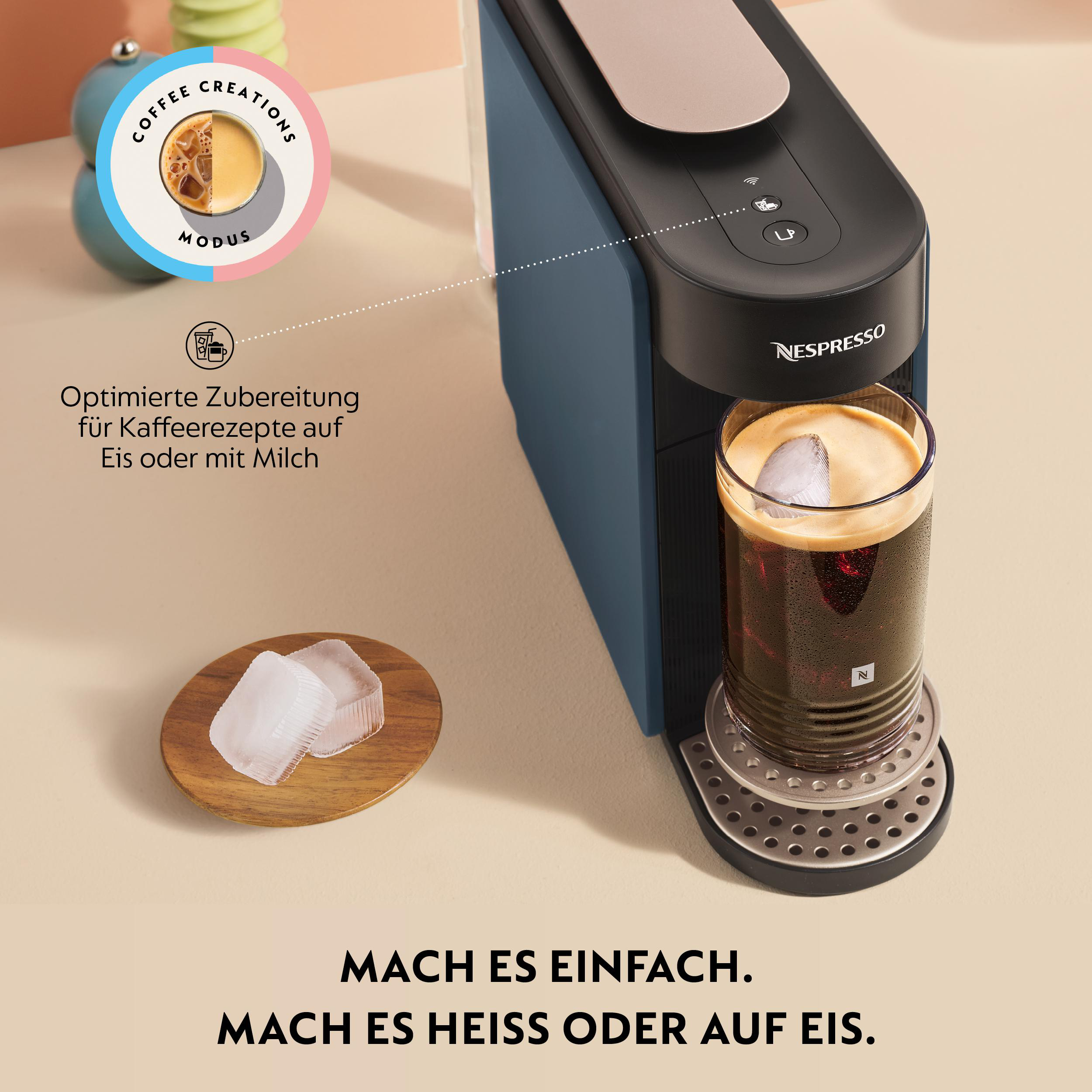 Eine Nespresso-Maschine brüht Kaffee mit Eis in einem Glas. Daneben Eiswürfel auf einem Holzbrett.