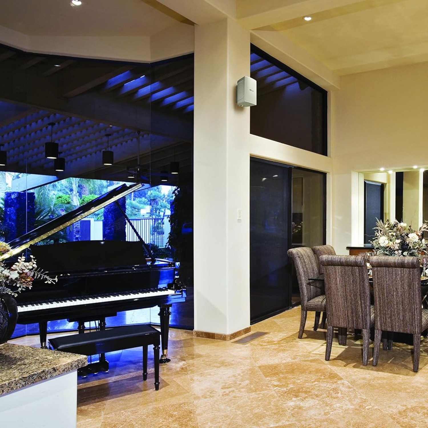 Un pianoforte a coda nero con panchetto si trova in una stanza elegante con sedie da pranzo.