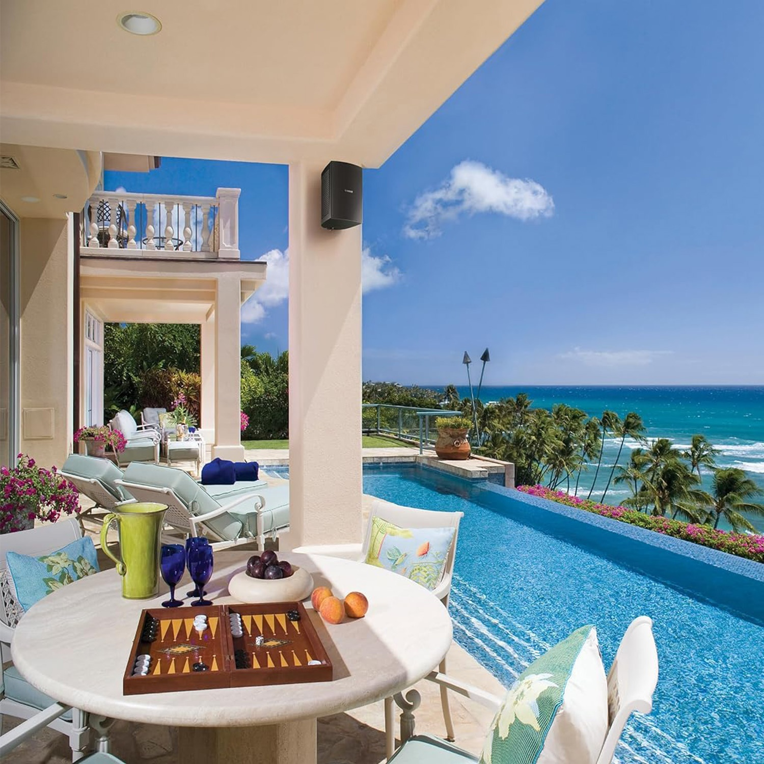 Un tavolo da pranzo con backgammon davanti a una piscina a sfioro e vista sull'oceano.