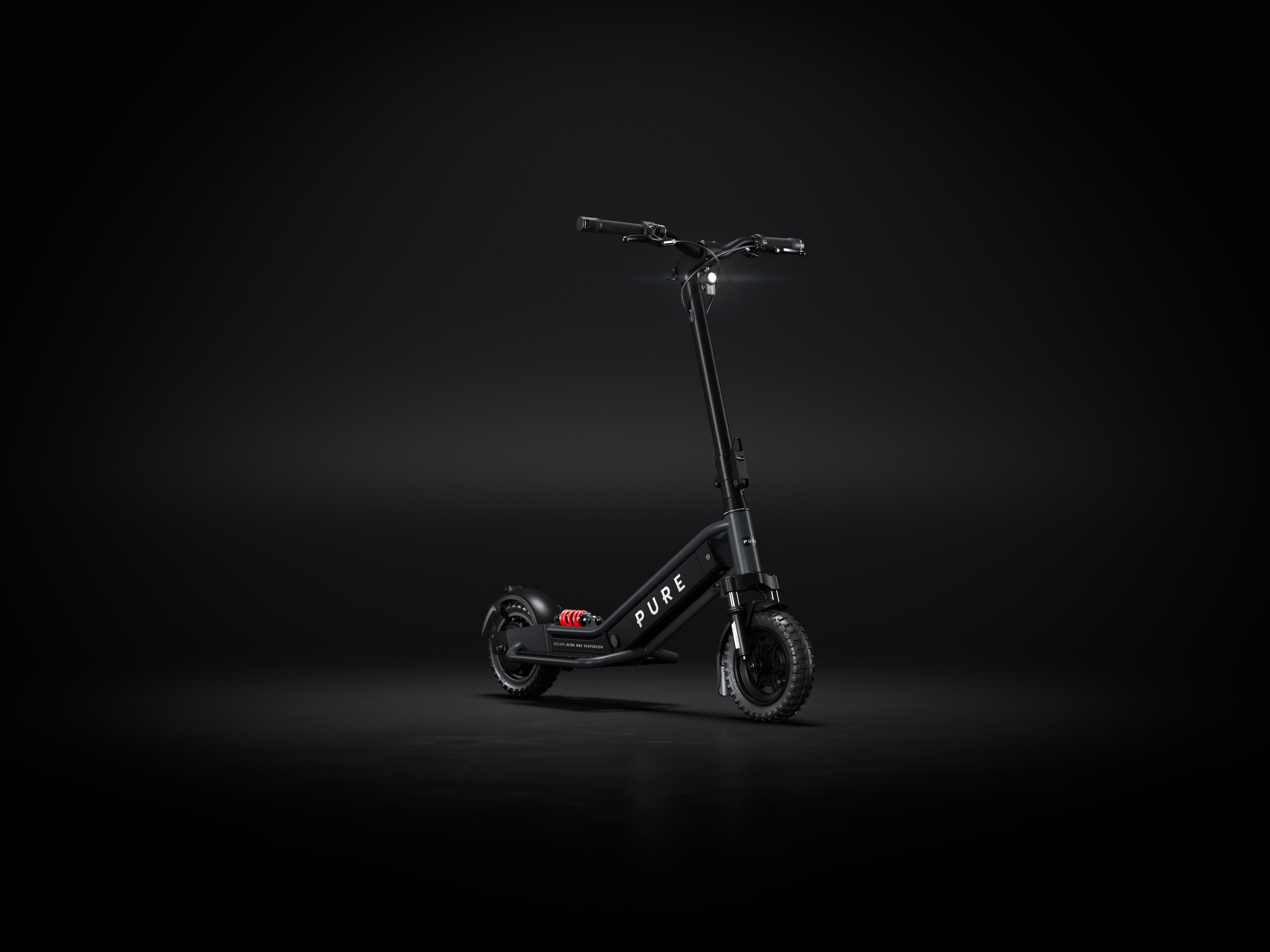 Ein schwarzer E-Scooter mit Federung und Lichtern auf dunklem Grund.