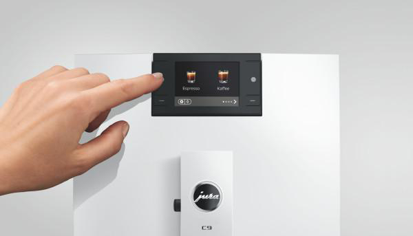 Eine Hand berührt den Touchscreen einer Kaffeemaschine mit Espresso- und Kaffeesymbolen.