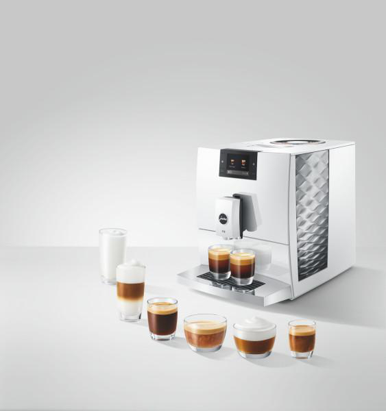Weiße Kaffeemaschine mit verschiedenen Kaffeespezialitäten in Gläsern.