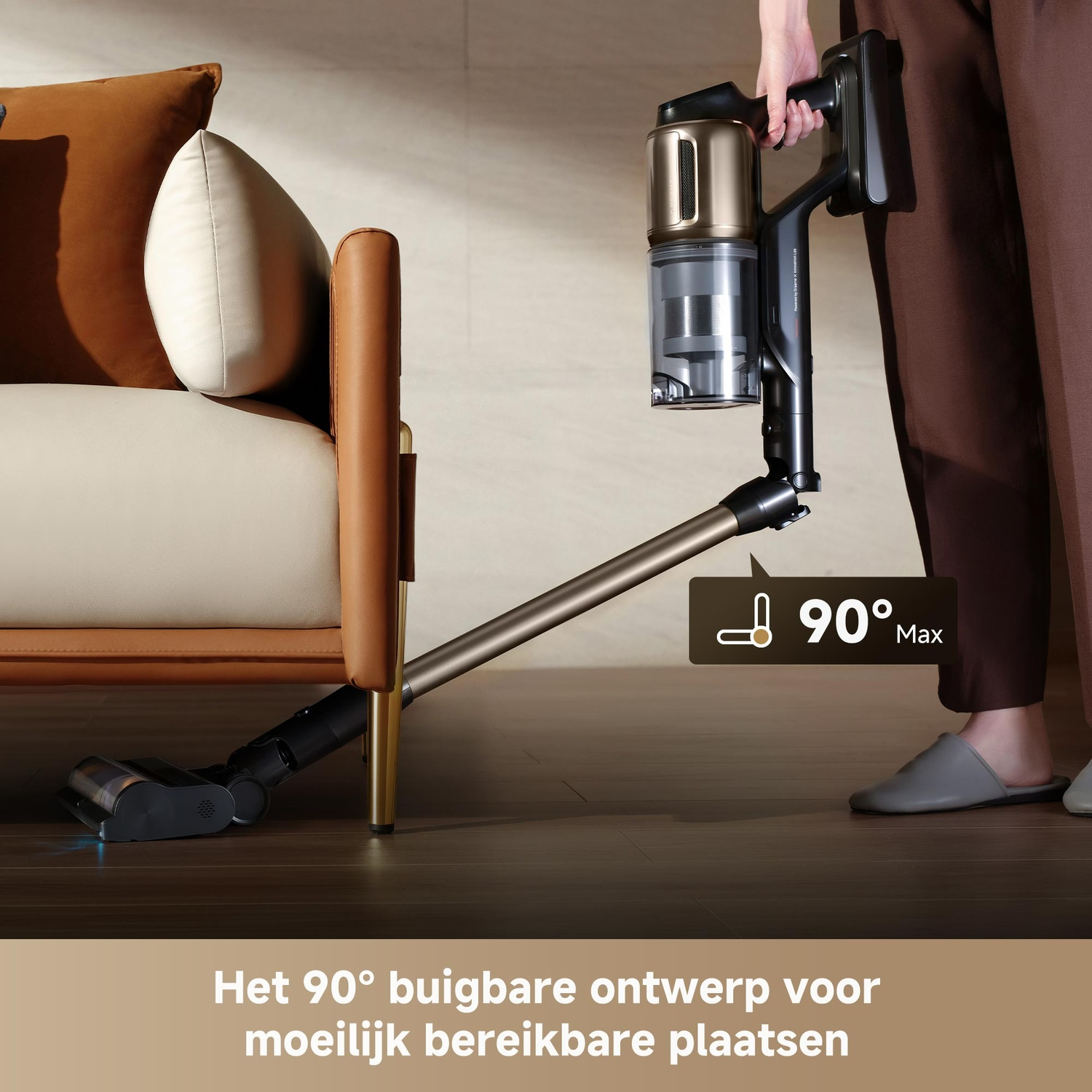 Un aspirateur au design flexible à 90 degrés nettoie sous un canapé.