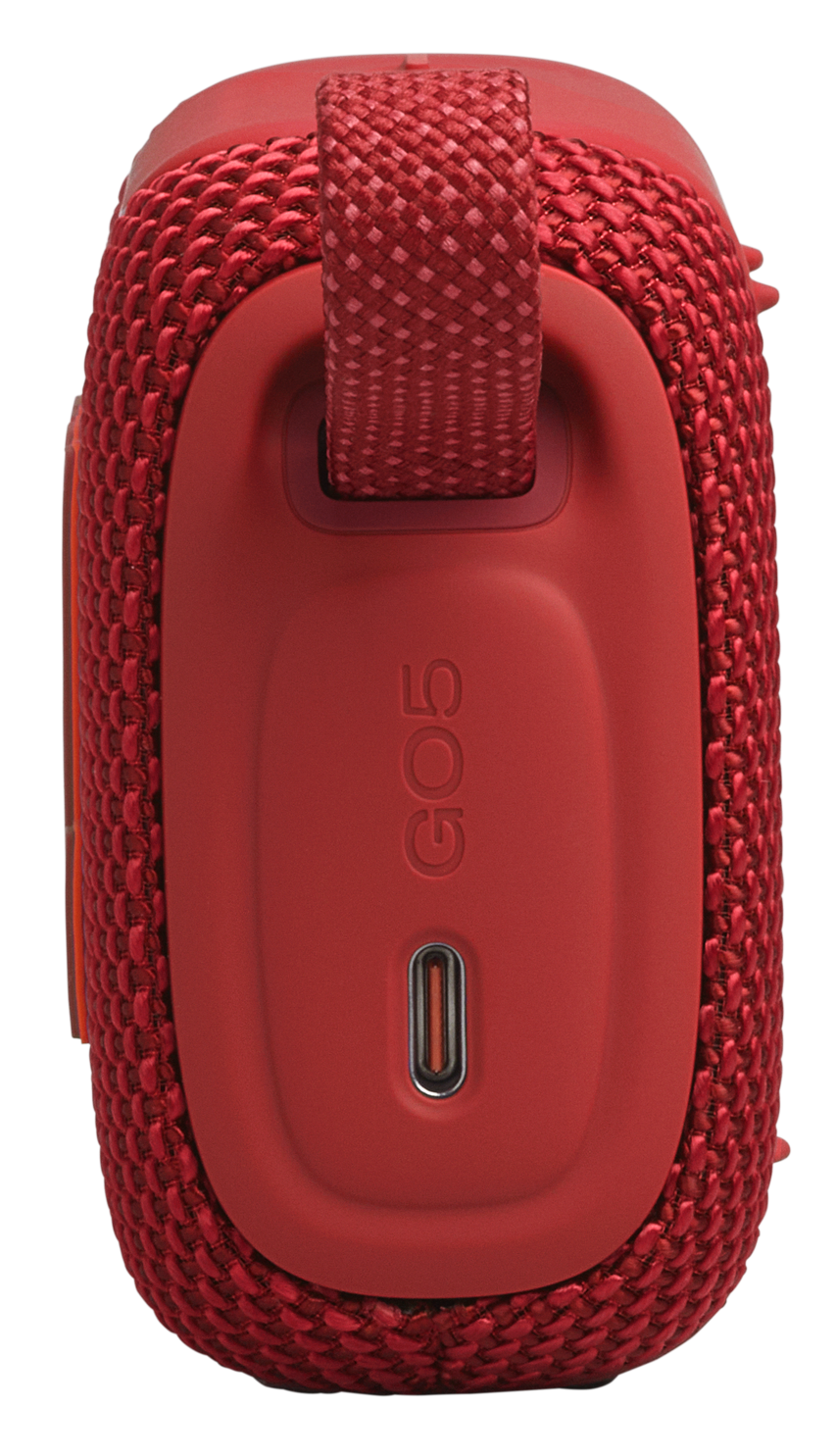 Czerwony głośnik pokryty tkaniną z paskiem i portem ładowania.