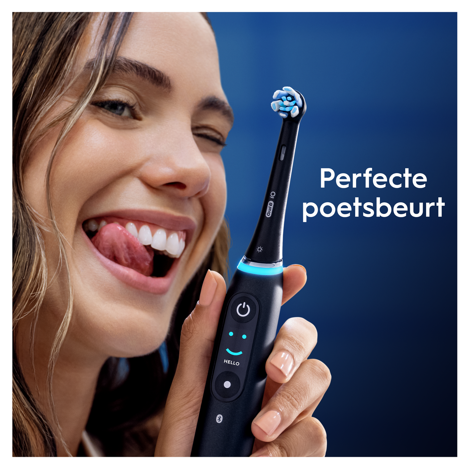 Woman with electric toothbrush, tongue out, smiling.