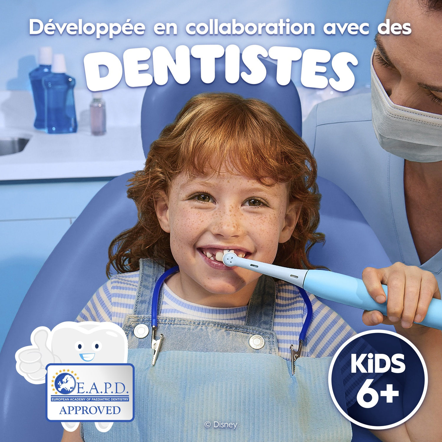 Une fille rousse se brosse les dents avec une brosse à dents électrique bleu clair.