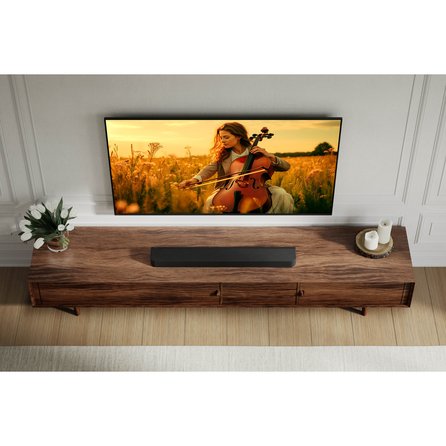 A woman plays cello in a field at sunset. A black soundbar sits on a wooden console.