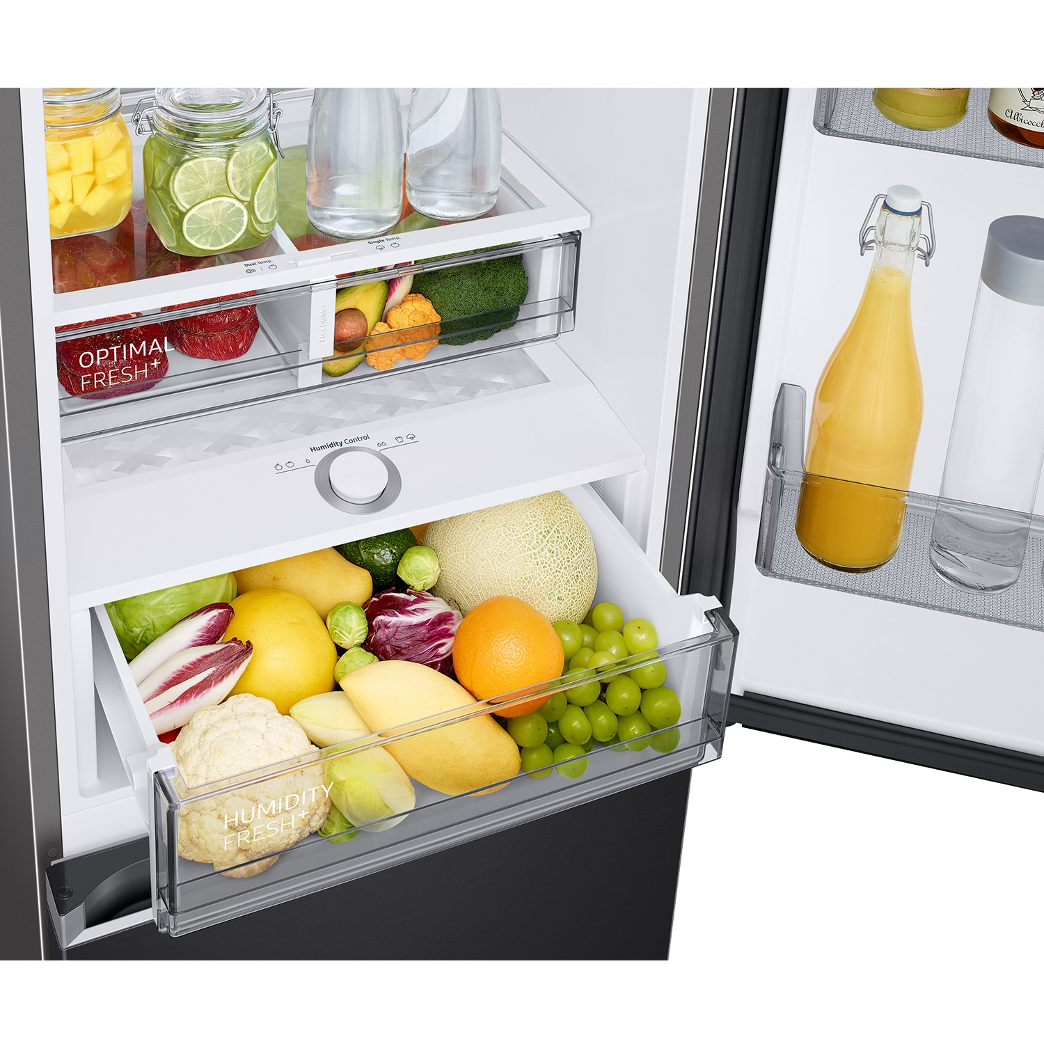 Refrigerador abierto con frutas y verduras frescas en cajones. Botella de jugo de naranja.