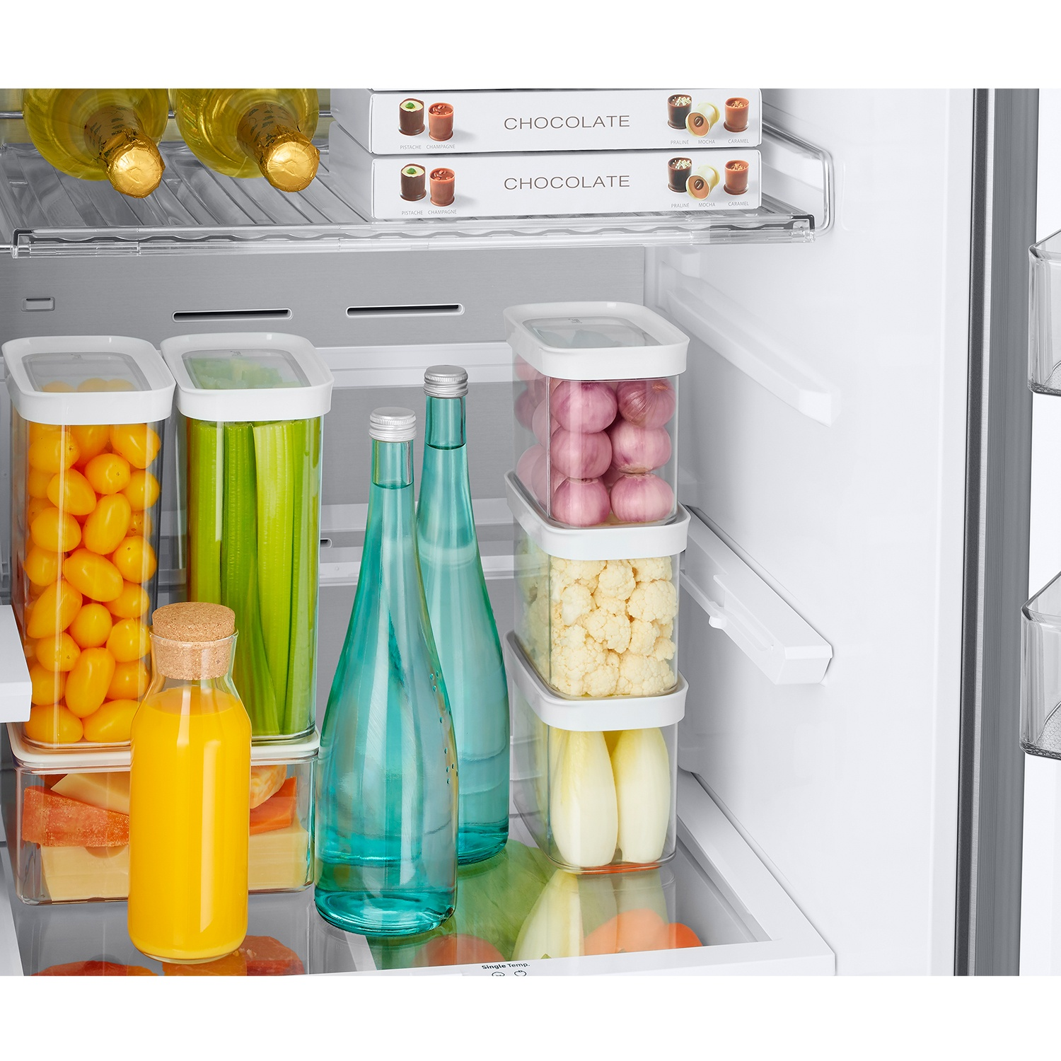 Refrigerador lleno de comida: botellas, chocolate, verduras y queso.
