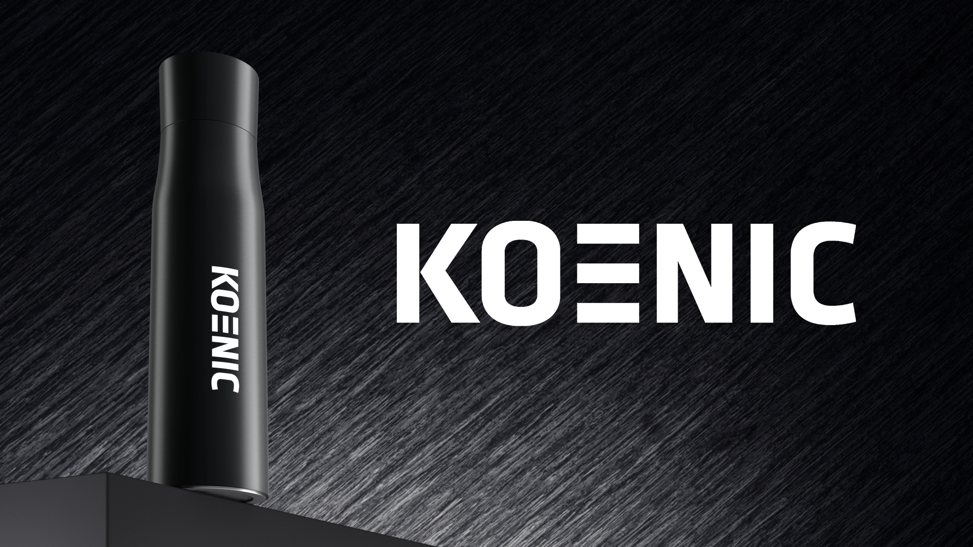 Schwarze Flasche mit dem weißen Logo KOENIC auf dunklem, texturiertem Hintergrund.