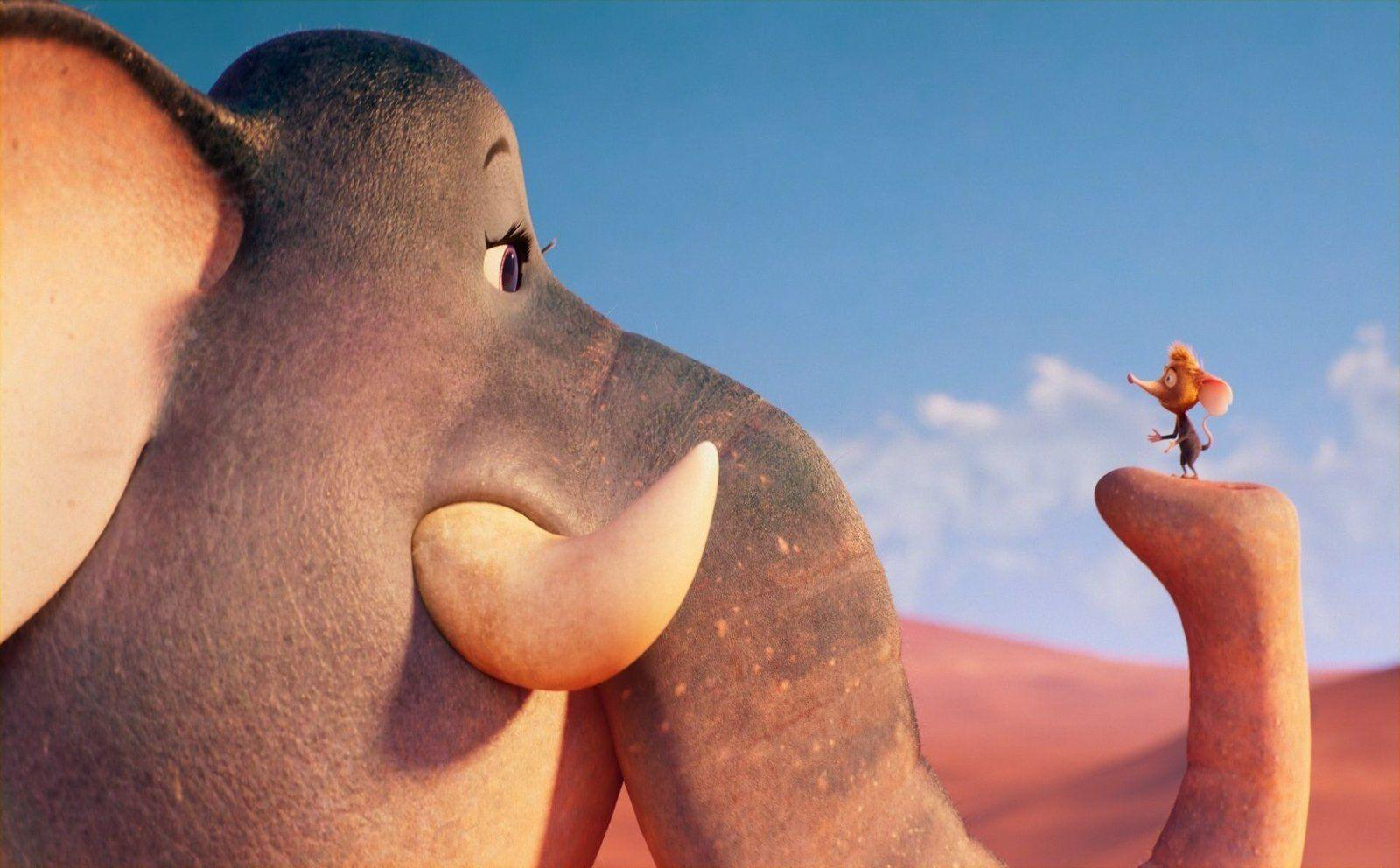Ein Elefant und eine Maus stehen sich in einer Wüstenlandschaft gegenüber.