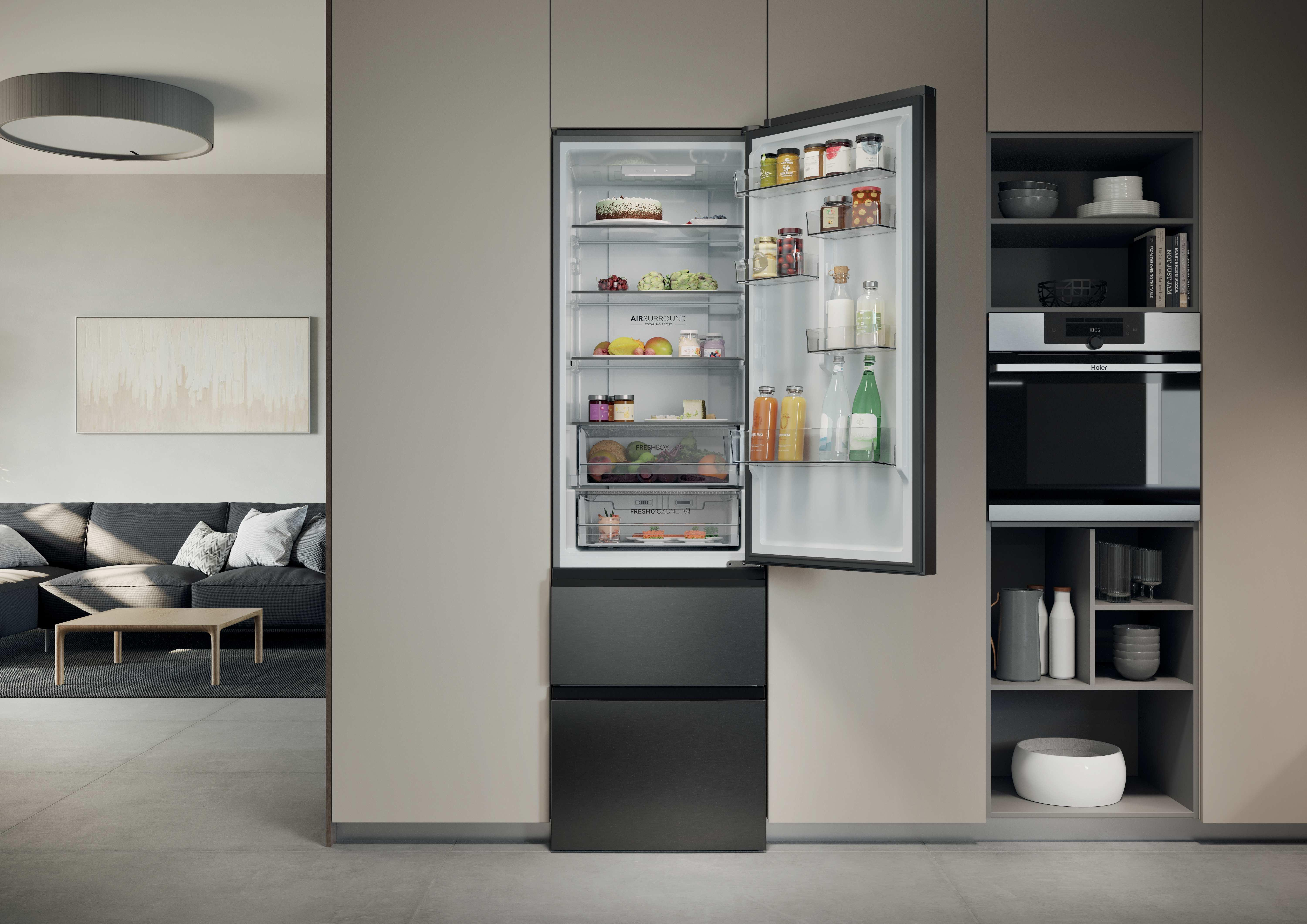 Offener Kühlschrank mit Lebensmitteln, daneben ein Wohnzimmer mit Sofa.