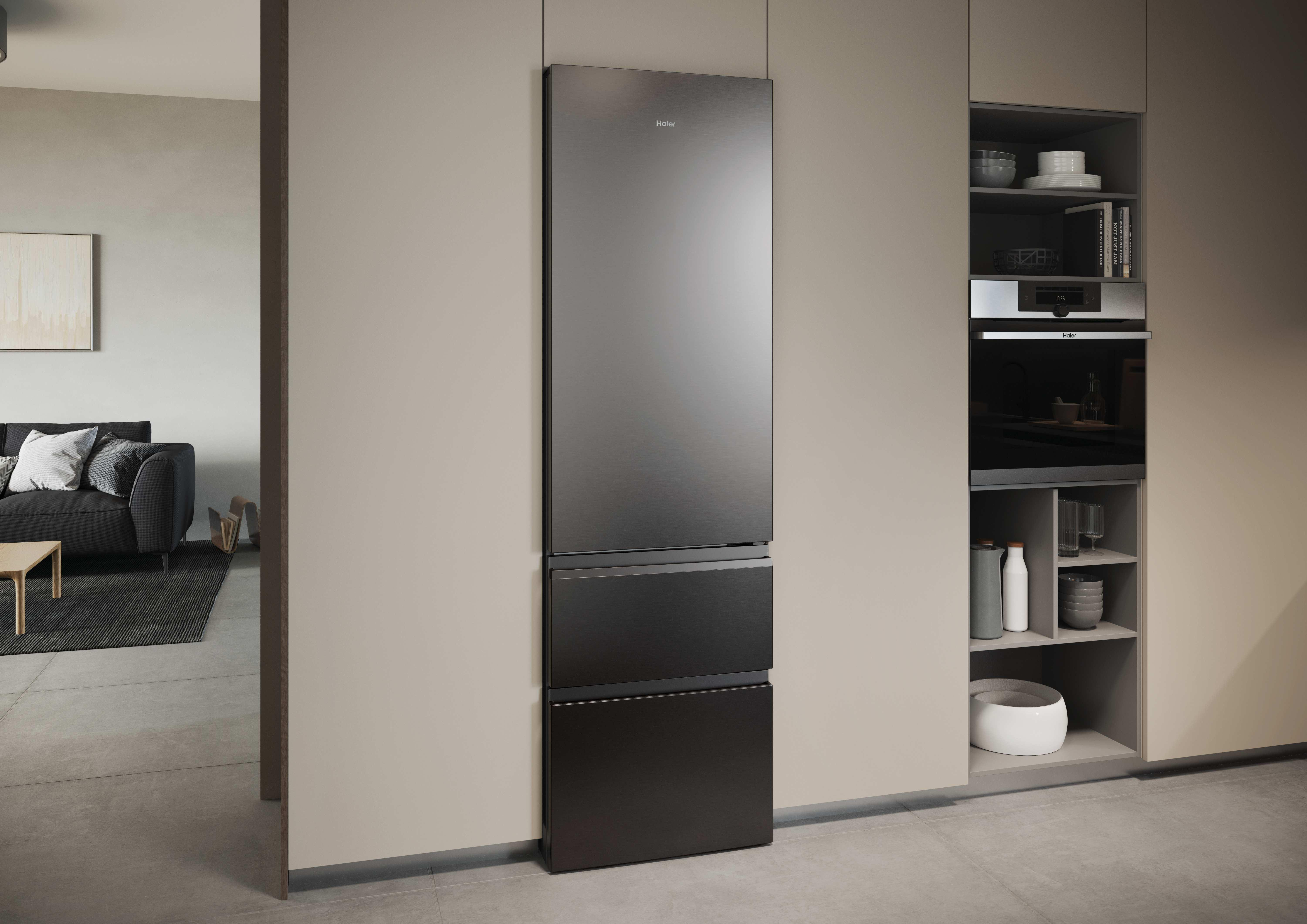 Ein moderner Kühlschrank und eingebauter Ofen in einer Küche. daneben ein Sofa.
