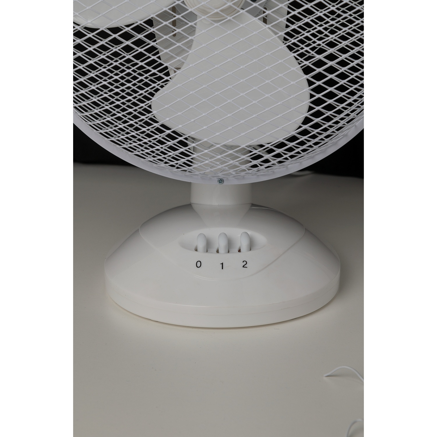 Gros plan d'un ventilateur de bureau blanc avec 3 réglages de vitesse.
