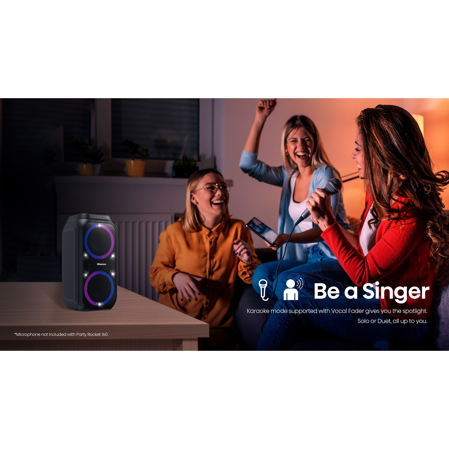 Tre donne cantano al karaoke davanti a uno speaker con luci colorate.