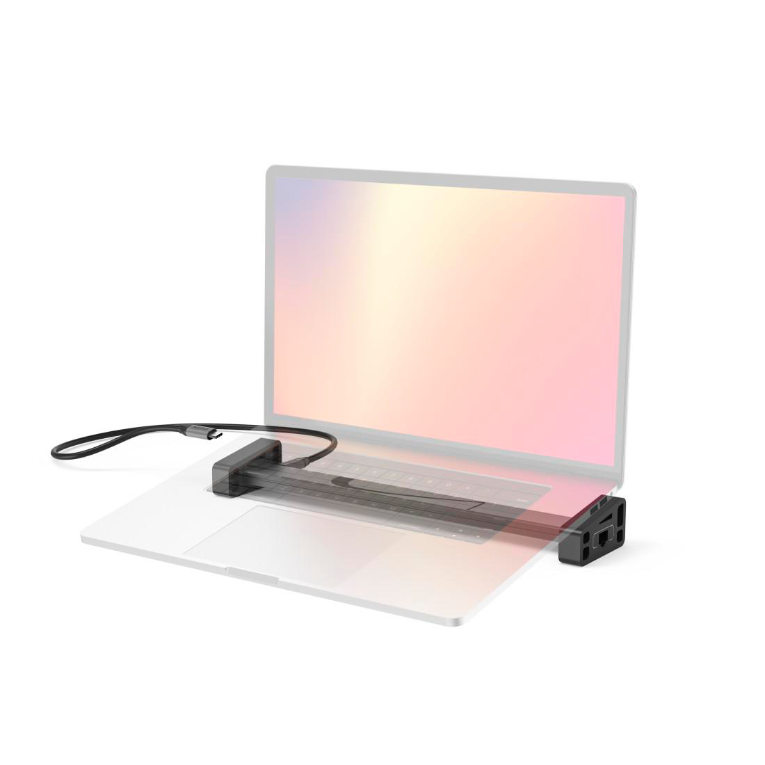 Ein schwarzer Kabeladapter ist an einem Laptop befestigt, der auf einer weißen Oberfläche steht.