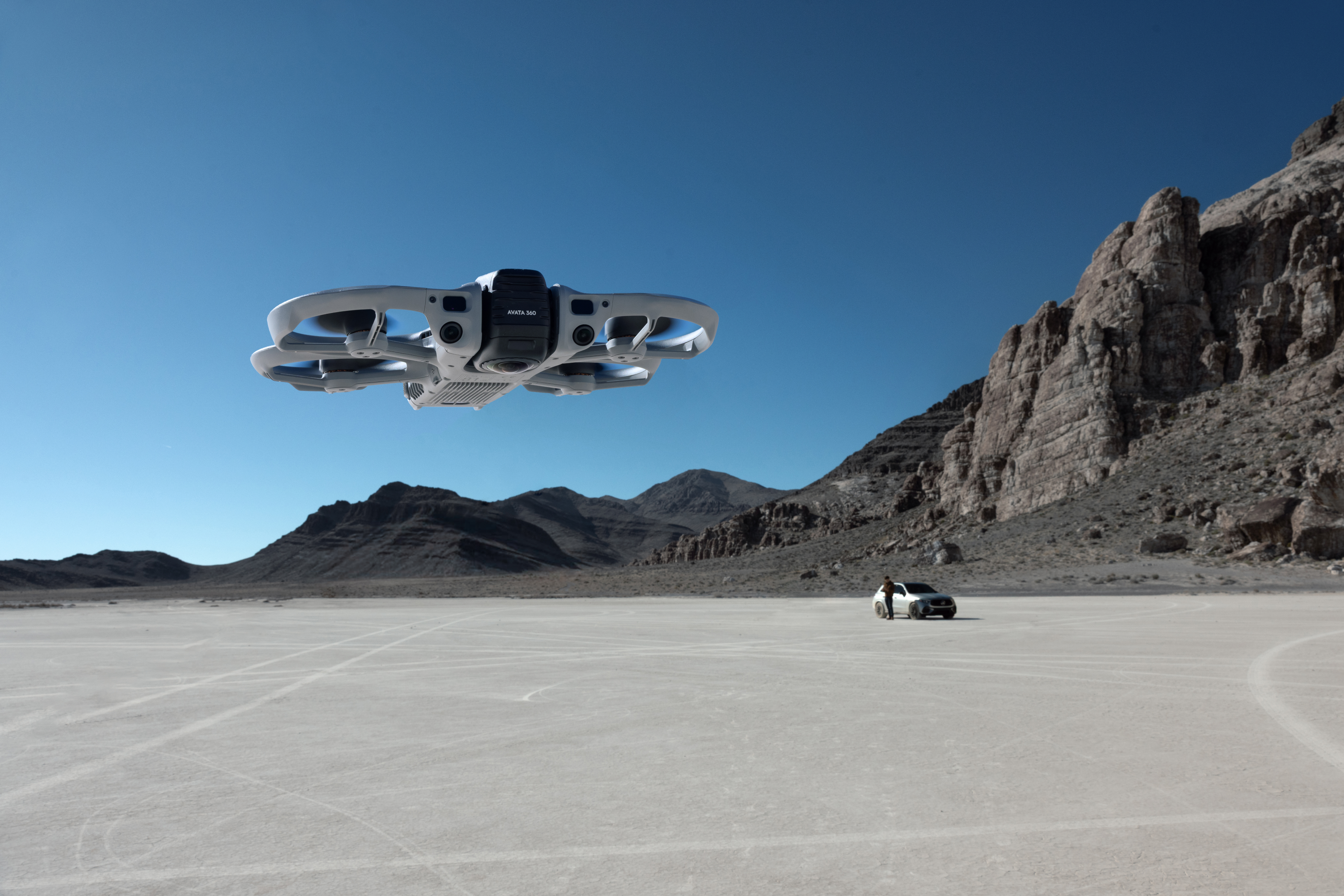 Un drone vola su un vasto deserto salato piatto con montagne sullo sfondo.
