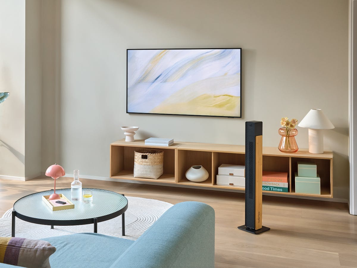 Ein Wohnzimmer mit Sofa, Couchtisch, Fernseher und einem Holzregal.