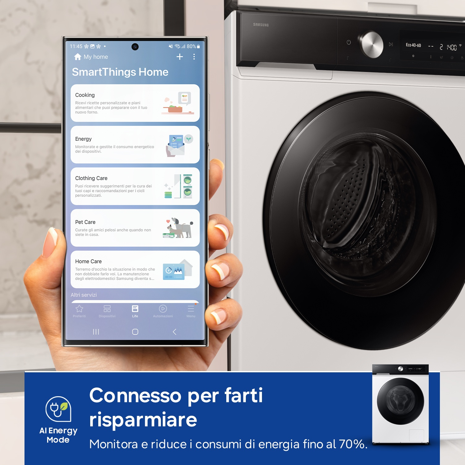Una mano tiene uno smartphone con l'app SmartThings accanto a una lavatrice Samsung.