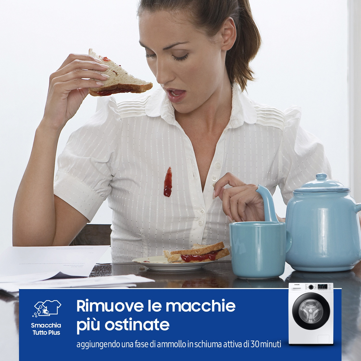 Donna con macchia di marmellata su camicetta bianca vicino a panino e teiera.