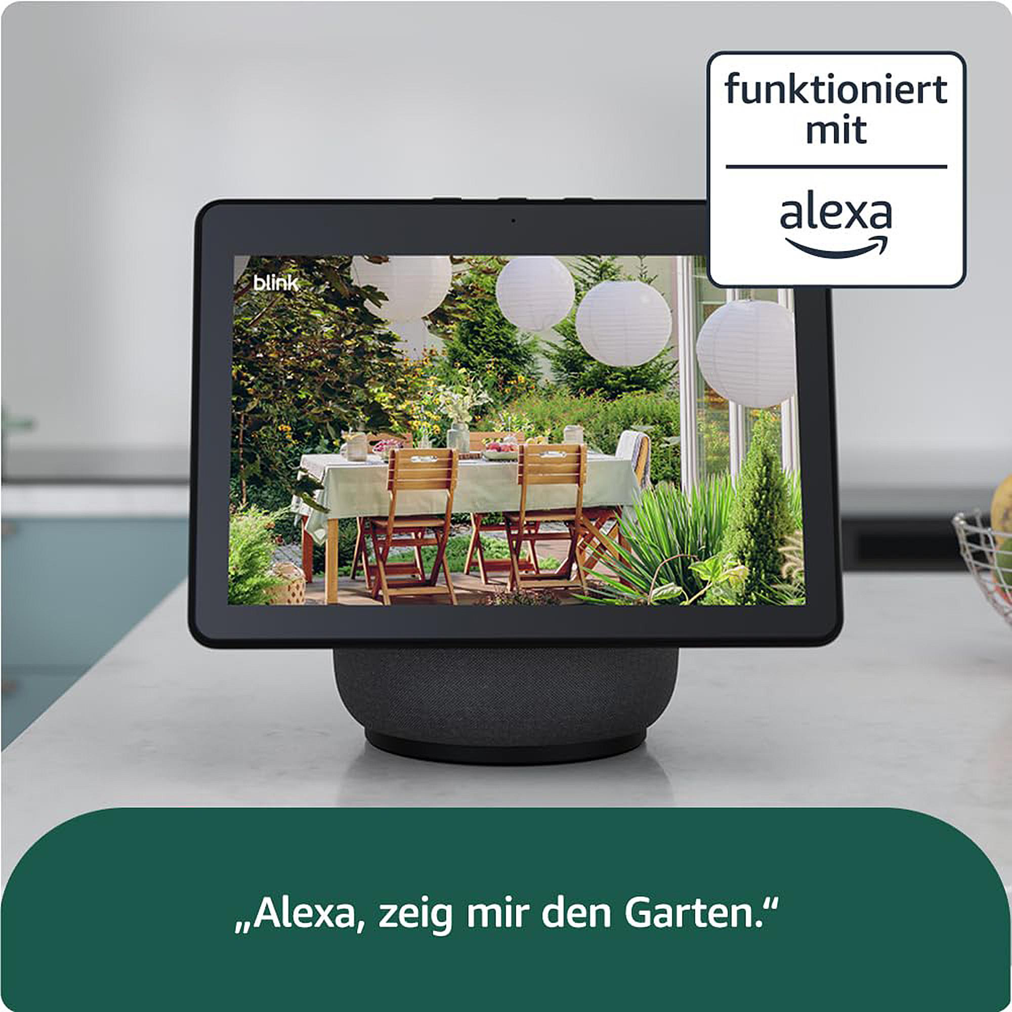 Ein Tablet zeigt einen Garten mit Tisch und Stühlen. "Funktioniert mit Alexa".