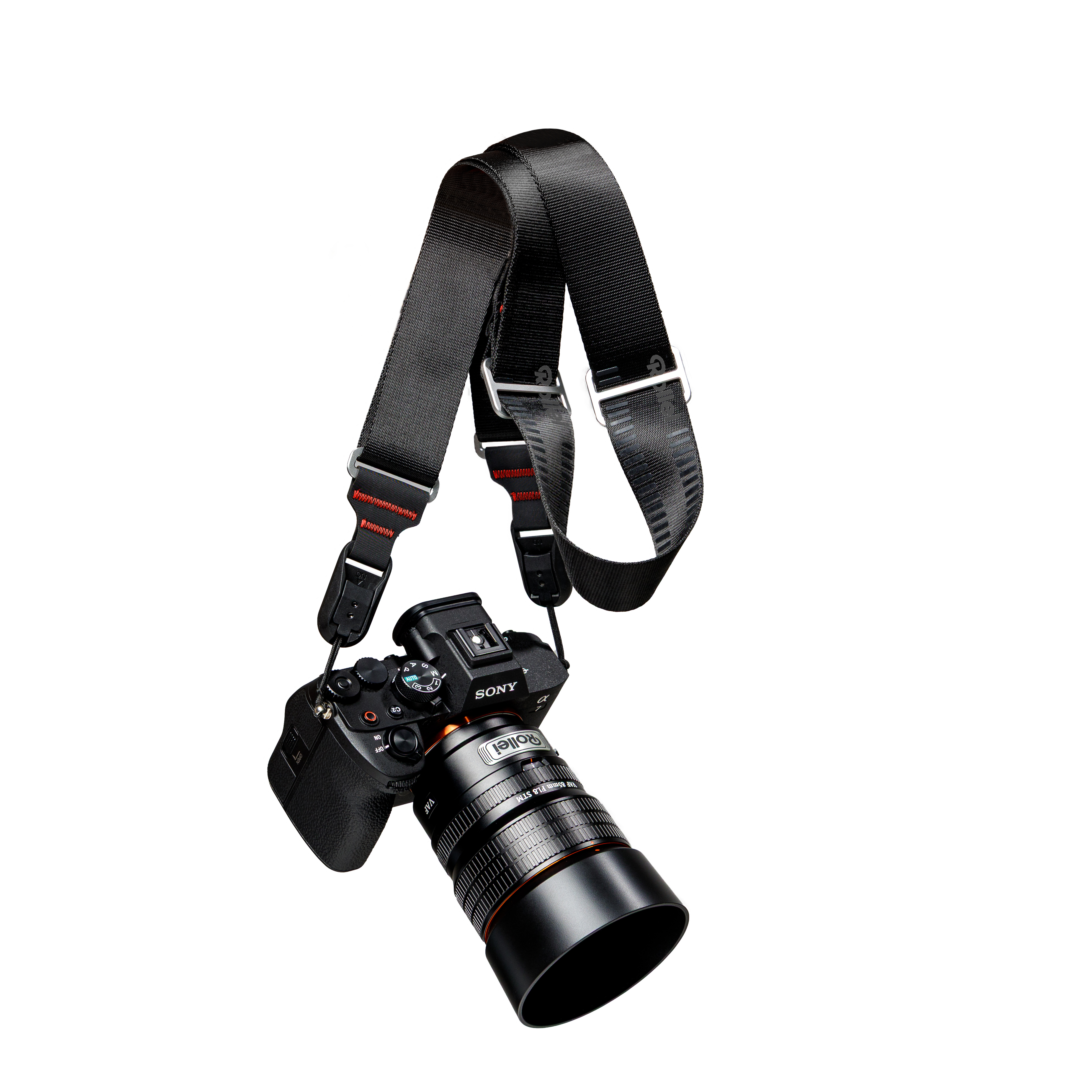 Sony Alpha 7 Kamera mit Rollei Objektiv und schwarzem Gurt auf weißem Hintergrund.