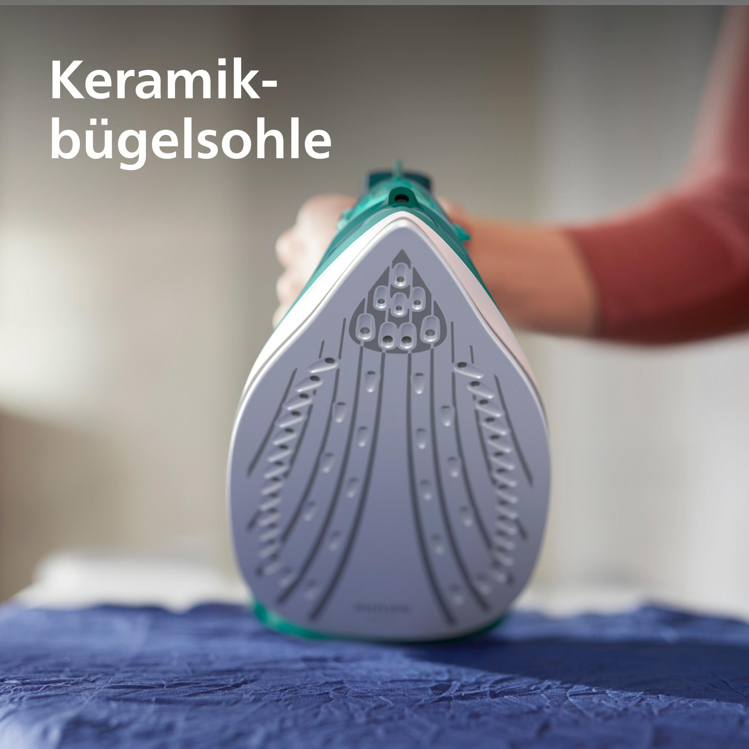 Bügeleisensohle mit Dampfdüsen auf blauem Stoff