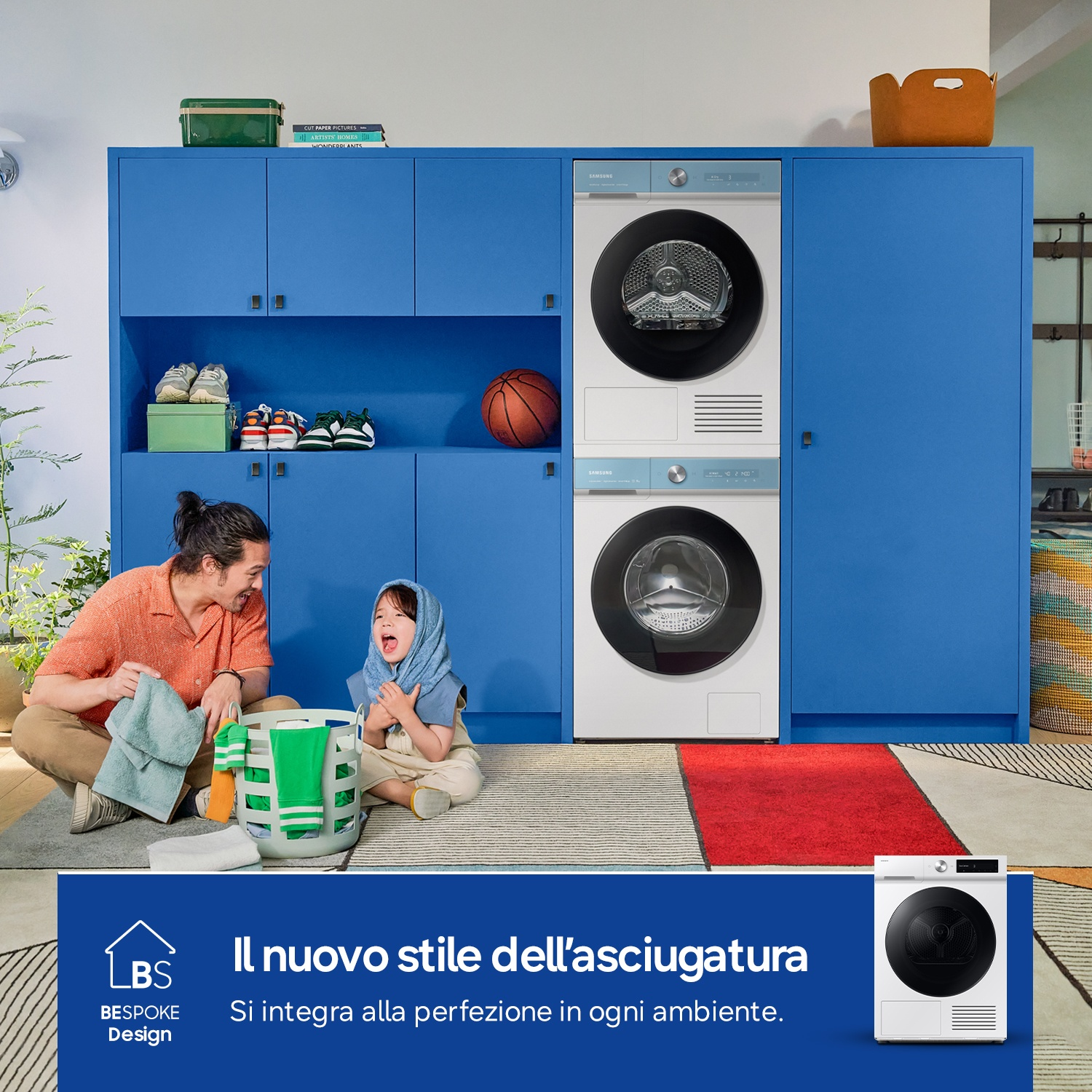 Padre e figlio con cesto della biancheria davanti ad armadi blu con lavatrice e asciugatrice.