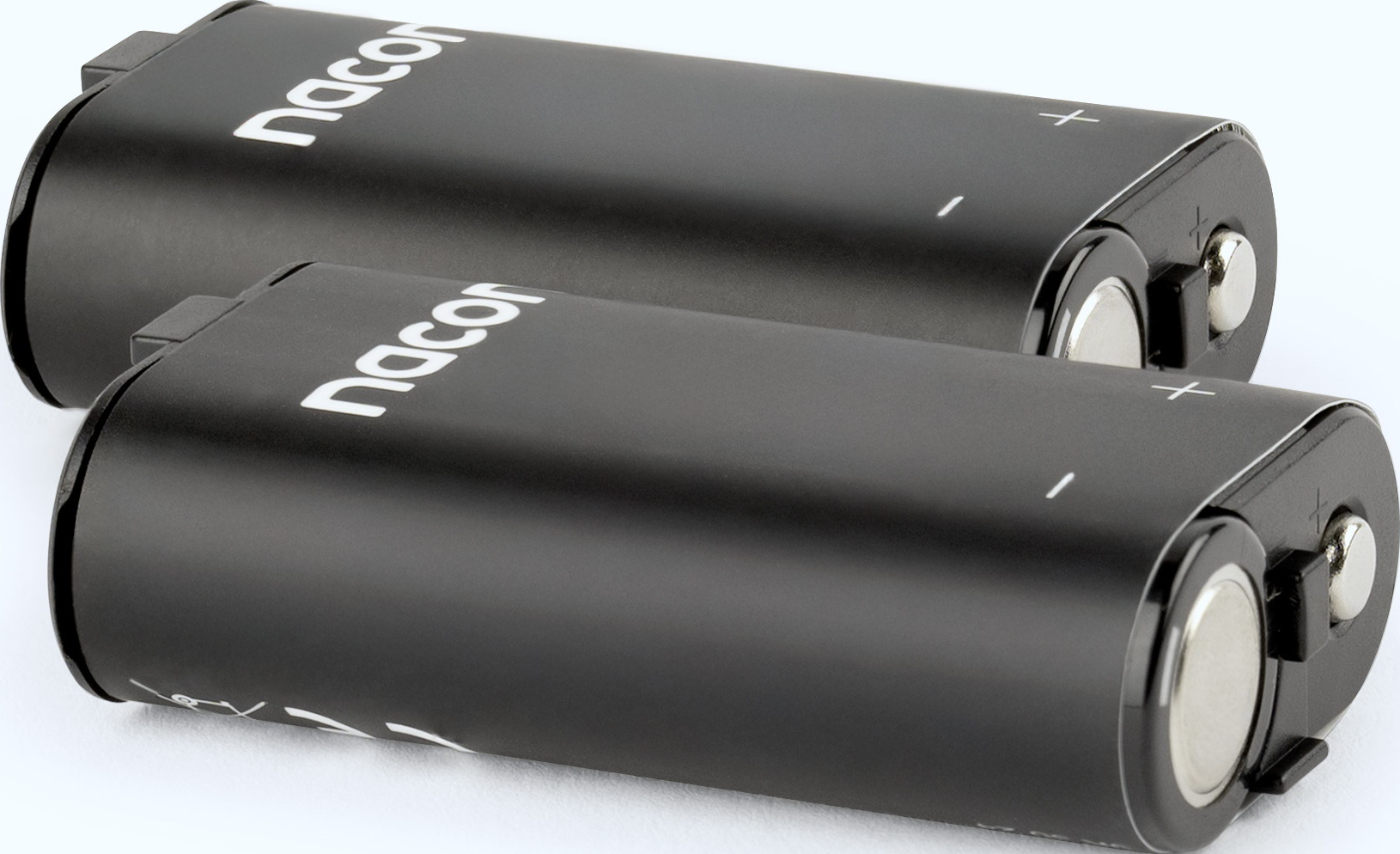 Zwei schwarze Nacon-Batterien liegen nebeneinander, mit Plus- und Minuspolen.