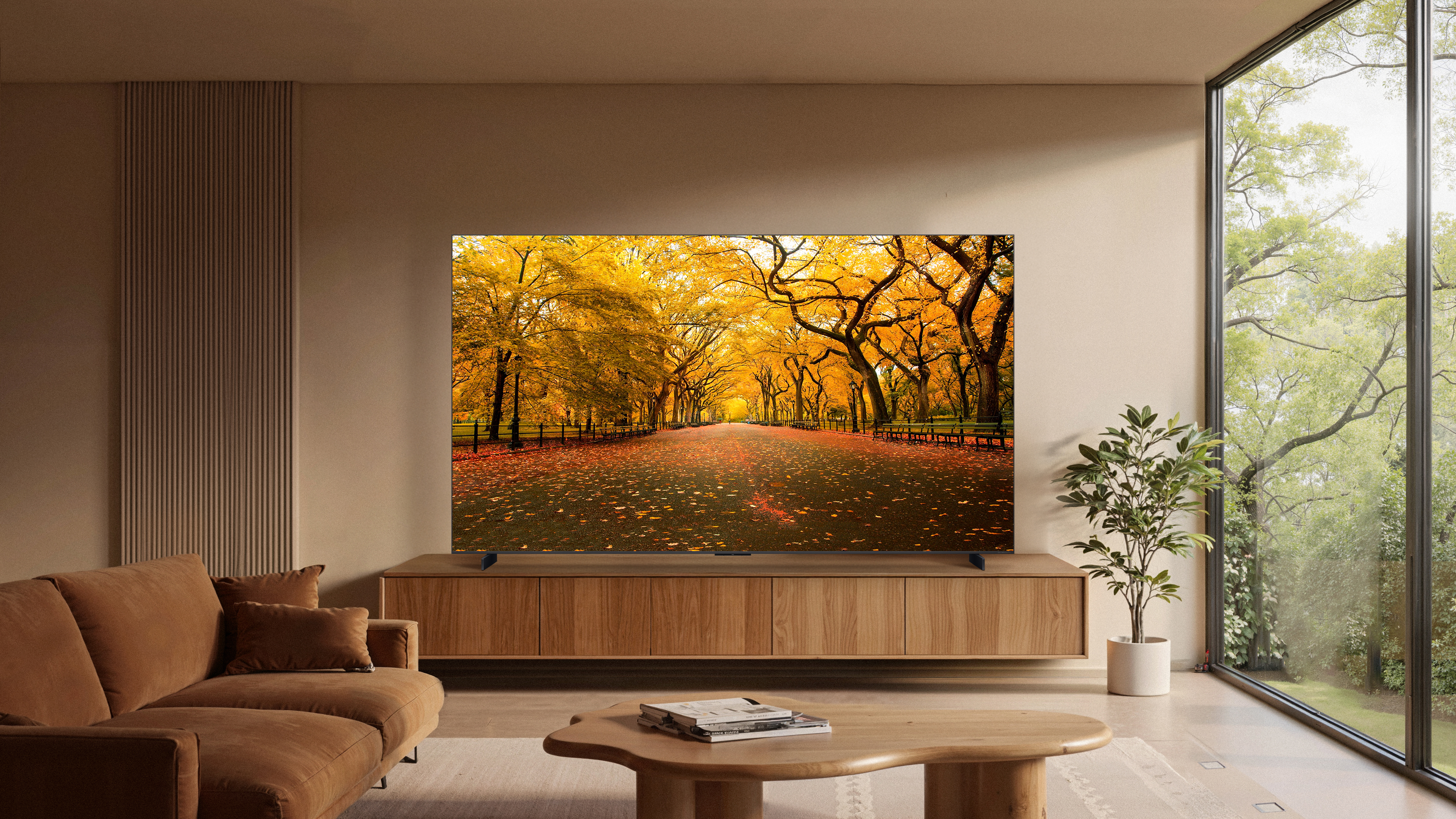 Ein Wohnzimmer mit Sofa, Couchtisch und Fernseher, der einen Herbstweg zeigt.