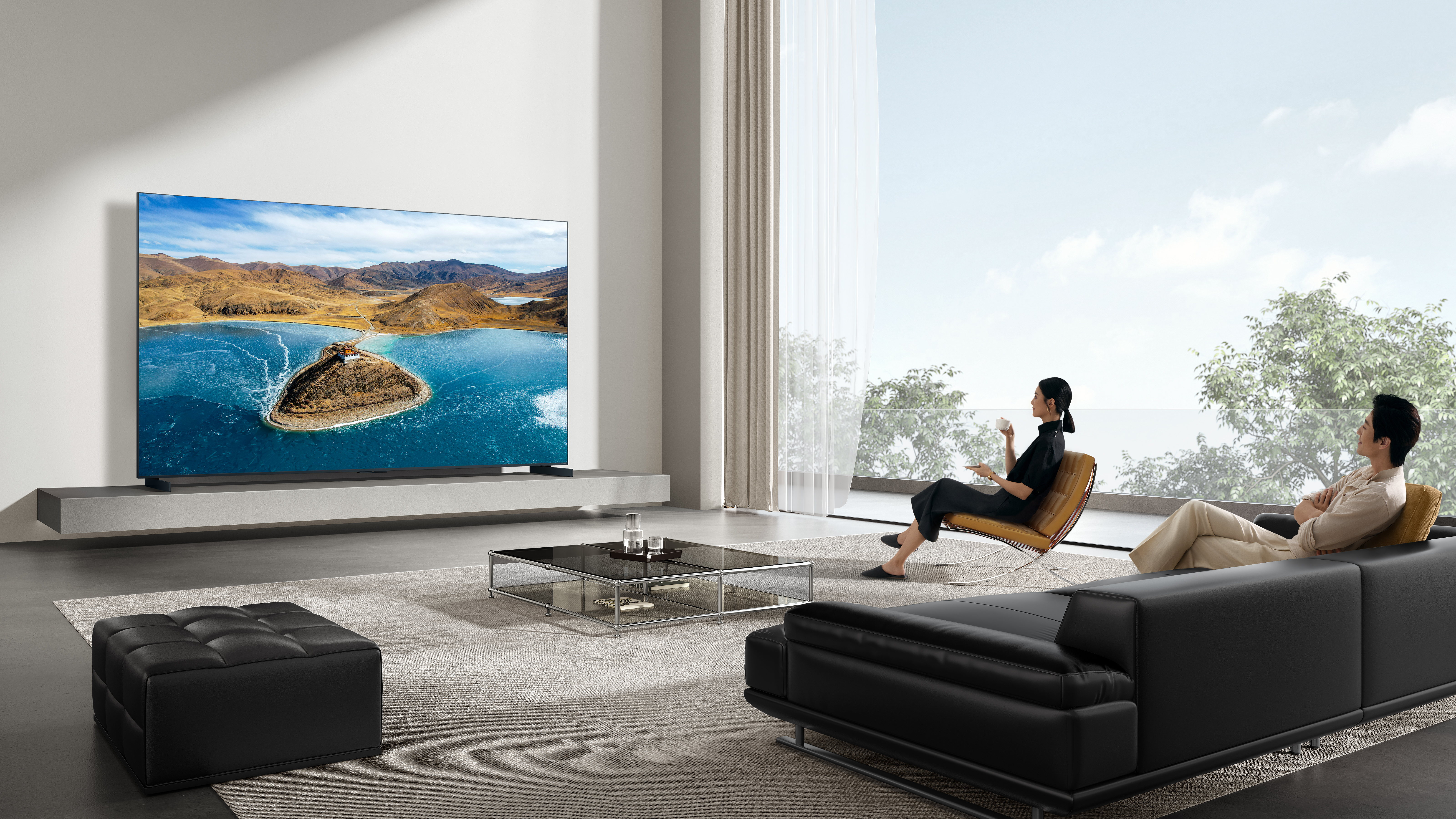 Ein Paar entspannt sich in einem modernen Wohnzimmer vor einem großen Fernseher.