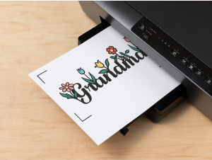 Una impresora imprime una hoja con la palabra "Grandma" y flores.