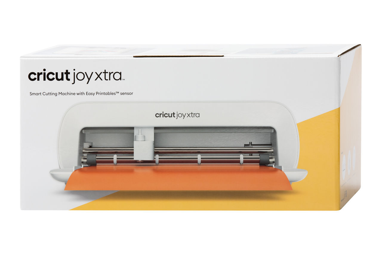 Una caja blanca con una máquina de corte Cricut Joy Xtra y material naranja.