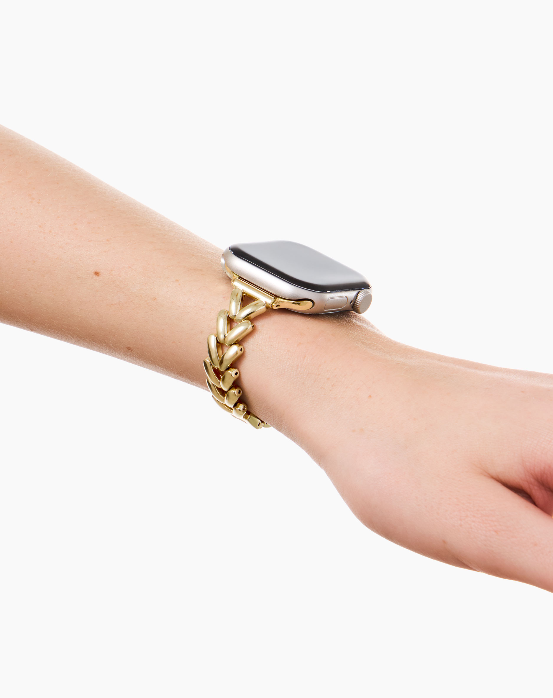 Eine menschliche Hand mit einer goldenen Uhr mit einem geflochtenen Armband.