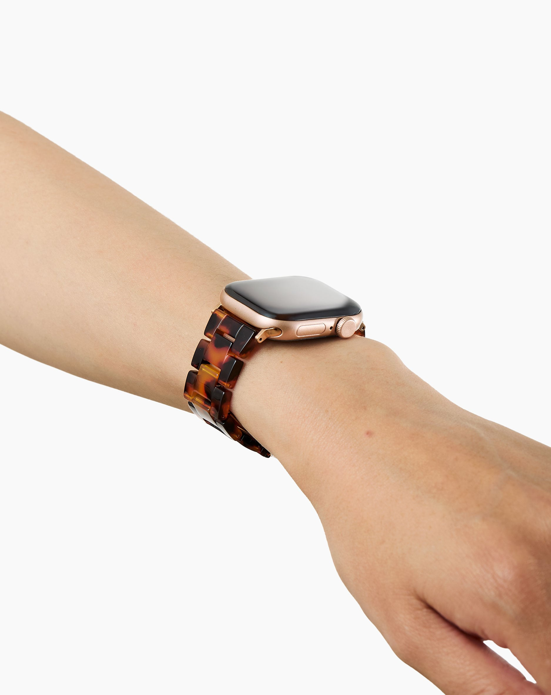Eine goldene Smartwatch mit Schildpattband an einem Arm.