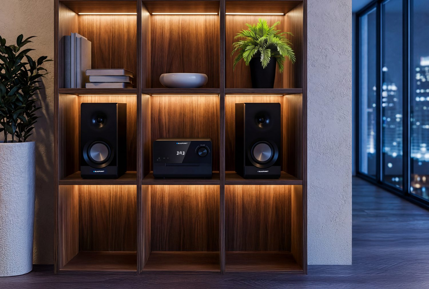 Półka z dwoma głośnikami, radiem DAB i roślinami. Widok na miasto.