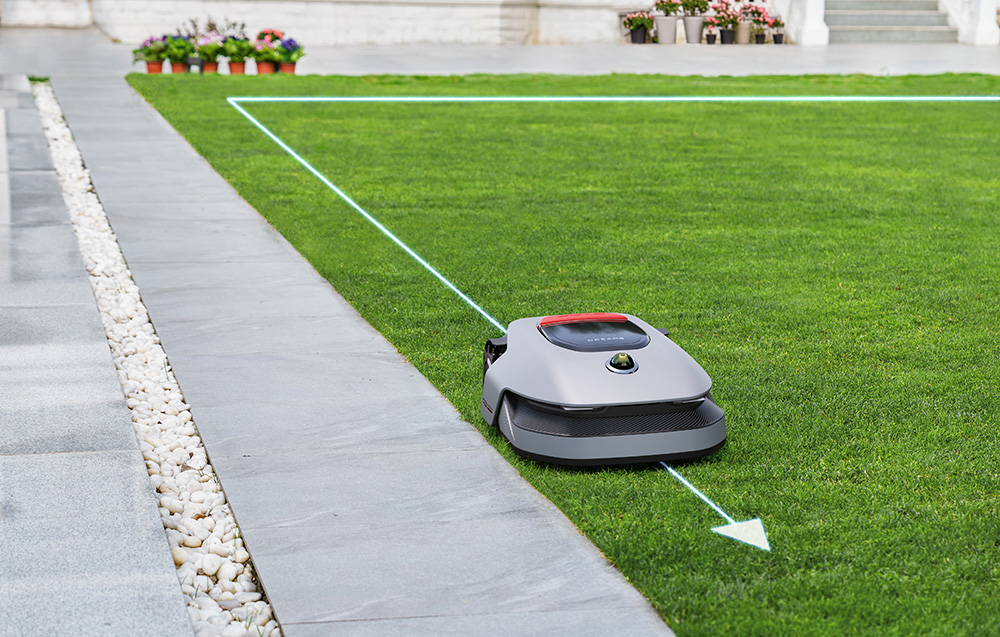 Robot koszący na zielonym trawniku z wirtualną linią graniczną.