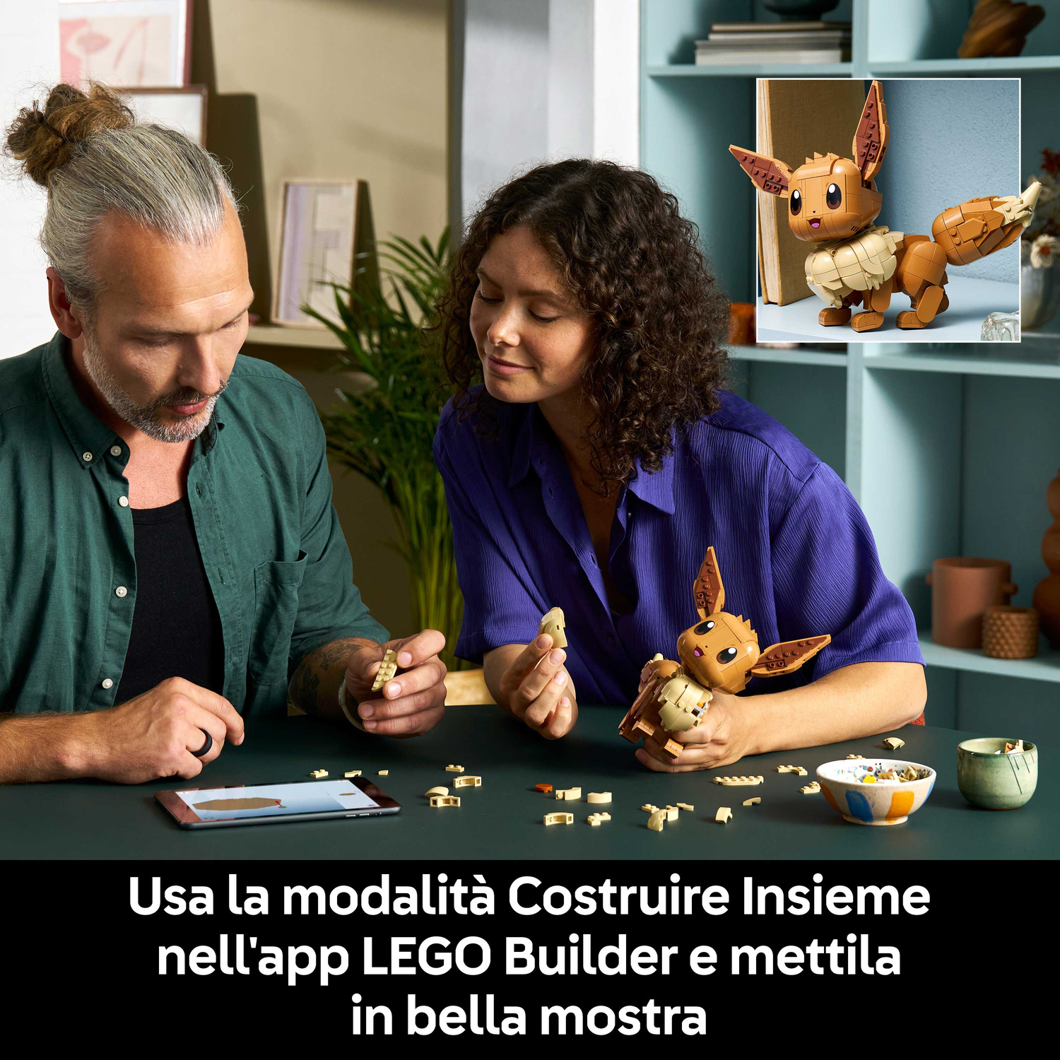 Due persone costruiscono un Pokemon Lego, con un modello finito nelle vicinanze.