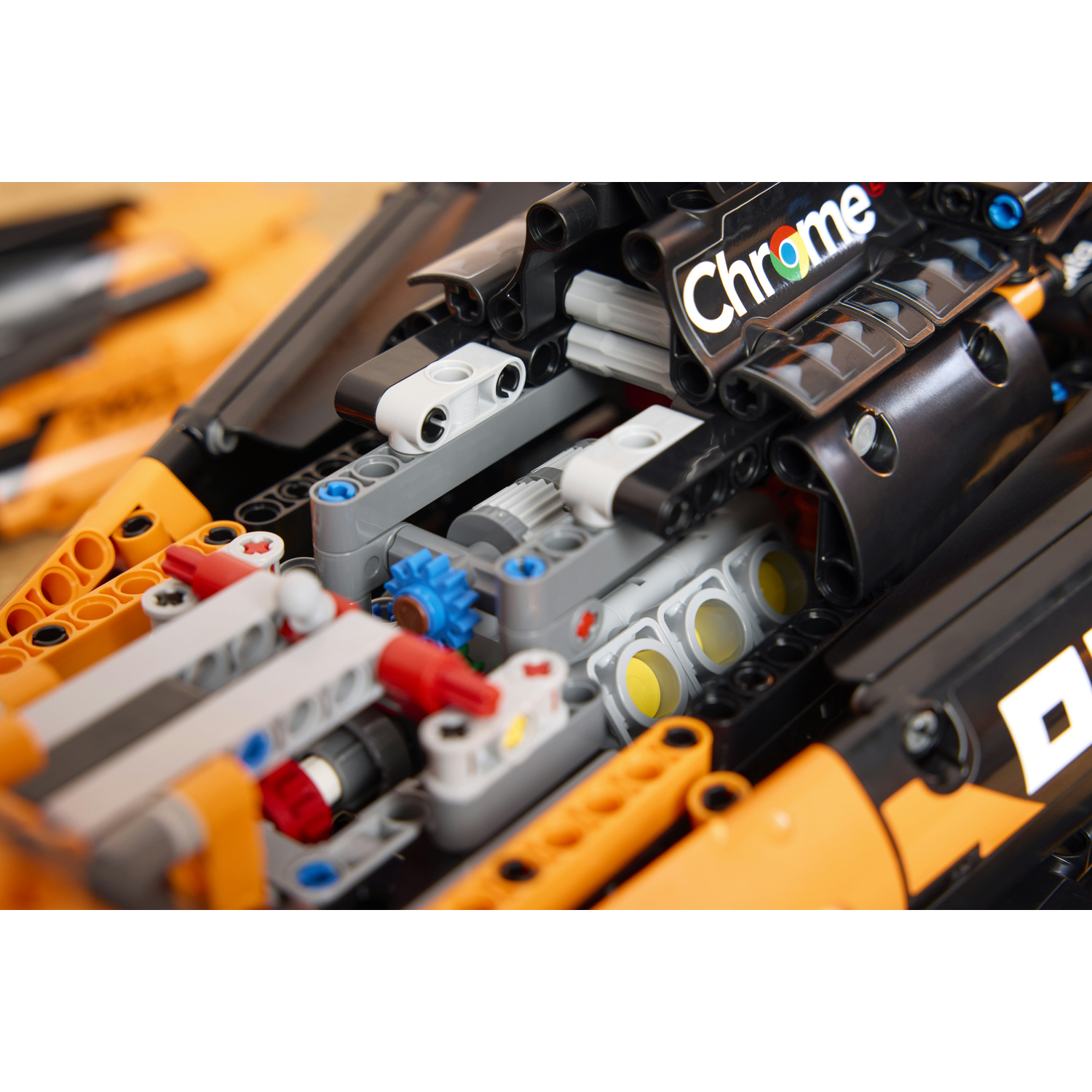 Primo piano di un dettagliato modello Lego con pezzi neri, arancioni e grigi.